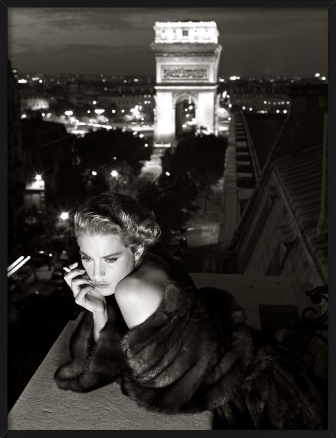 Lisa Kauffmann su un balcone a Parigi, una sigaretta in mano, l'Arco di Trionfo sullo sfondo - in look vintage.

Tutte le stampe sono in edizione limitata. Disponibile in più misure. Cornici di alto livello su richiesta.

Tutte le stampe sono