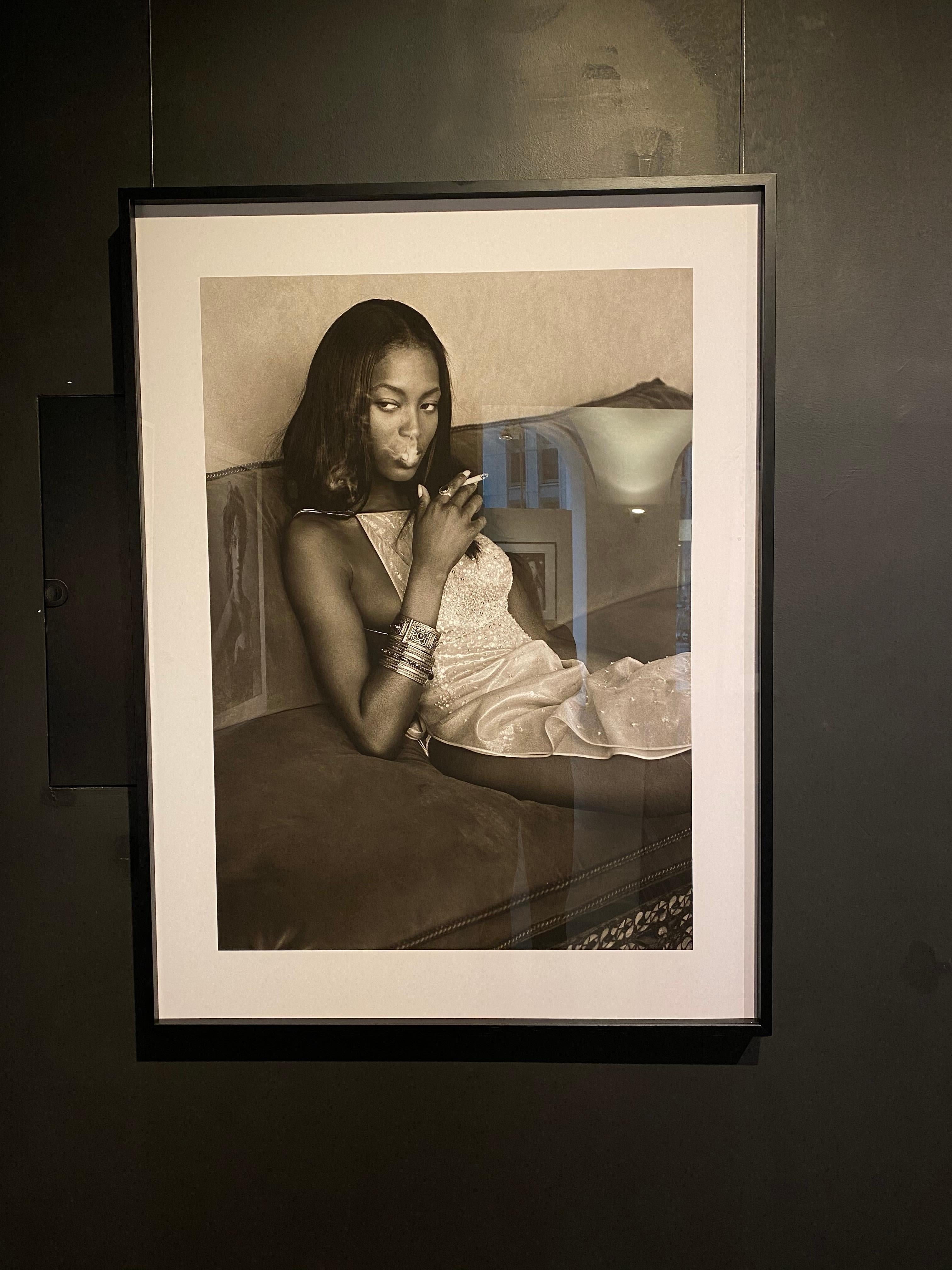 Naomi Campbell – das Supermodel, das auf einem Sofa raucht (Zeitgenössisch), Photograph, von Albert Watson