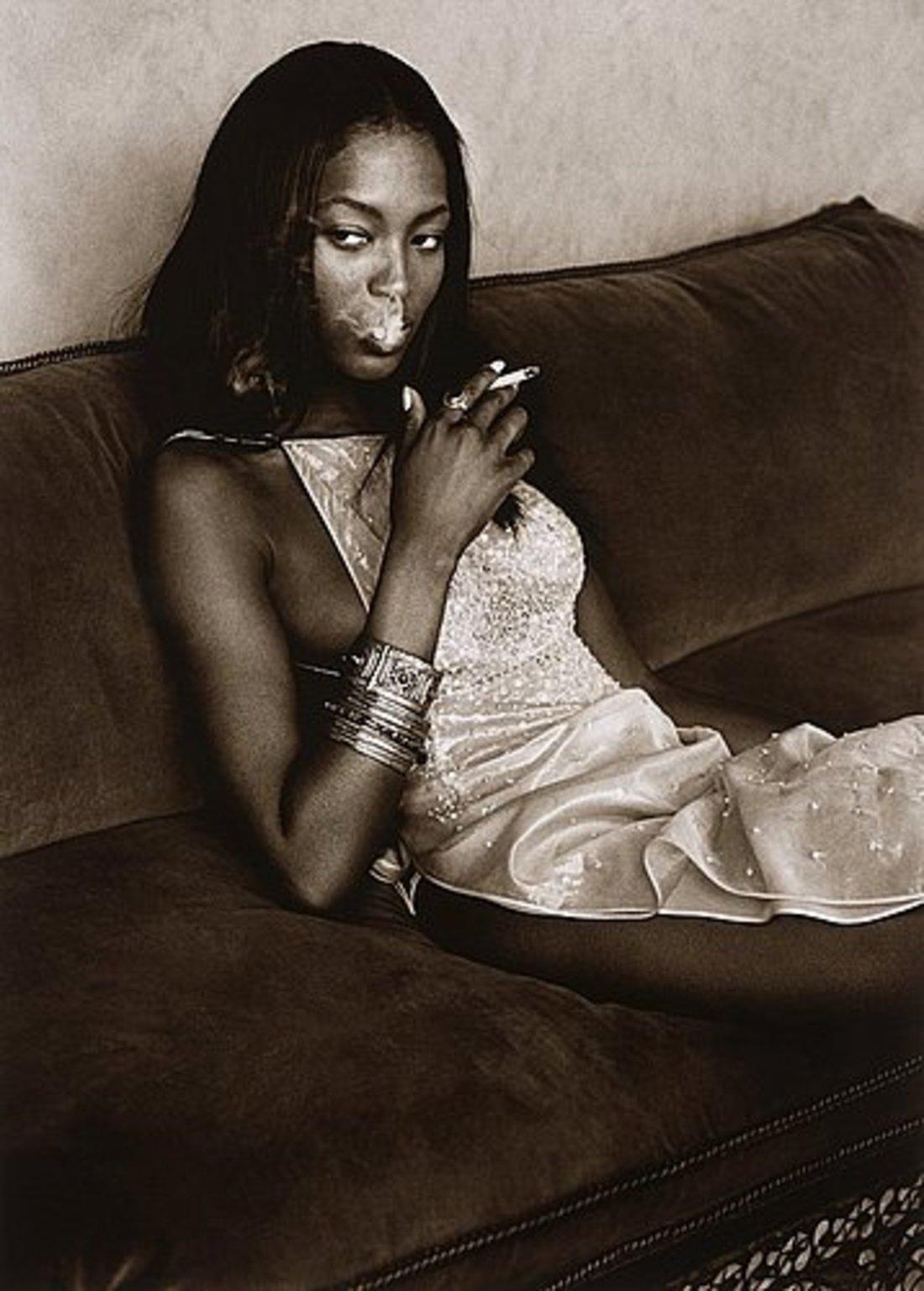 Albert Watson Portrait Photograph - Naomi Campbell - the supermodel smoking while sitting on a sofa