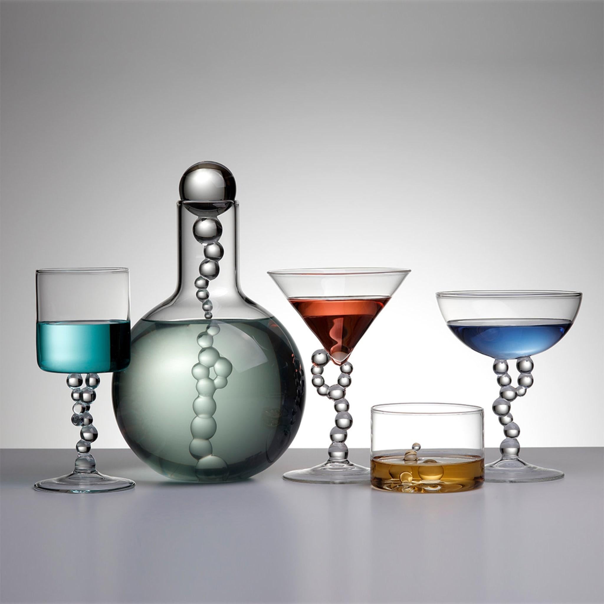 A collection composed of bottles, wine glasses, cocktail glasses and whiskey glasses, born from an ironic reinterpretation of chemical laboratory glassware. Vials, test tubes, funnels, and cylinders are
transformed into domestic objects, from which