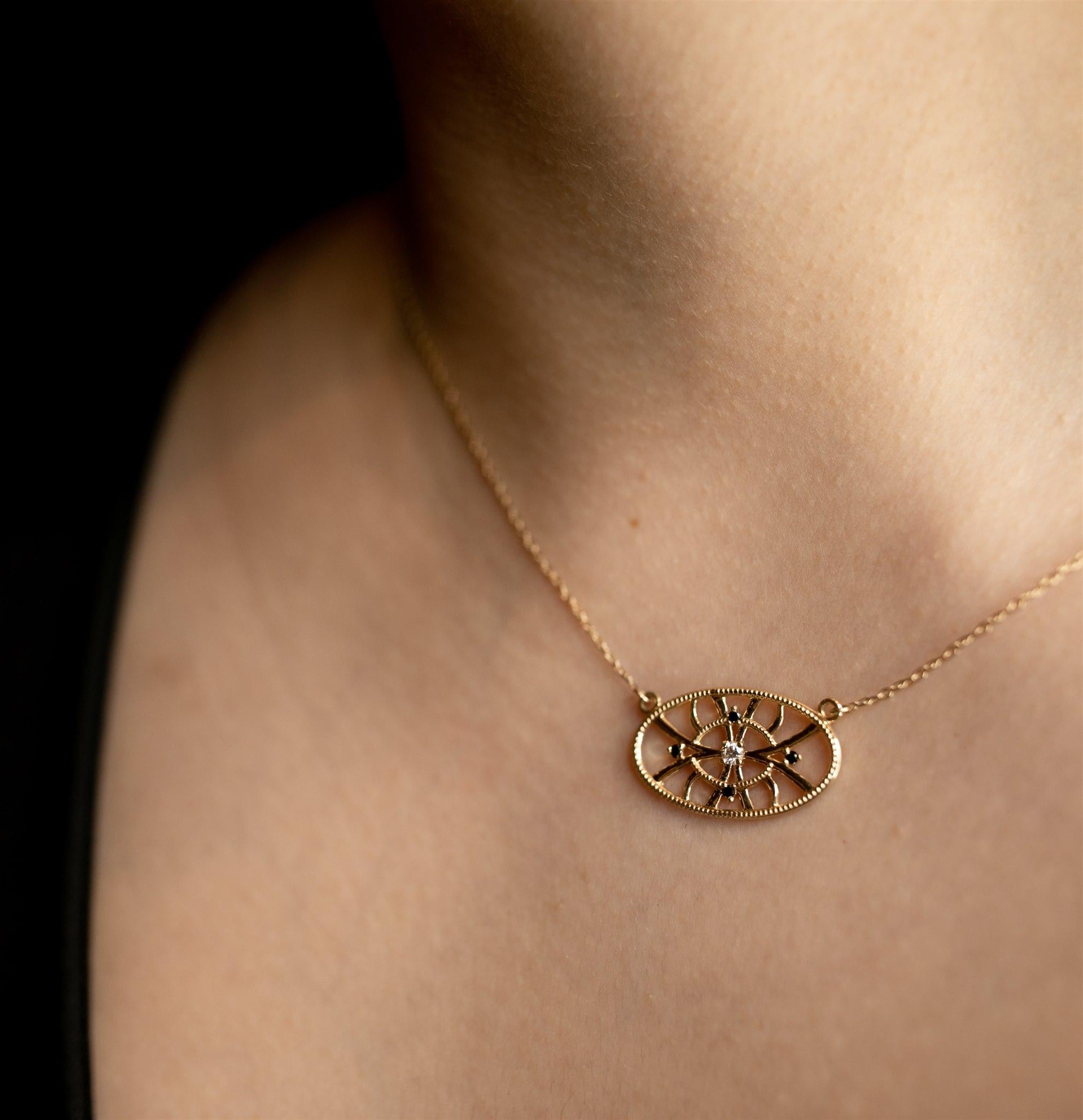 ALCHEMY
BEHOLD THE EXTRAORDINARY 
Four black diamonds sit amongst mystical swirls of hand engraved 14k gold, centering around a single glistening white diamond center on this delicate pendant. 

Materials: 14K Yellow Gold pendant on a 16