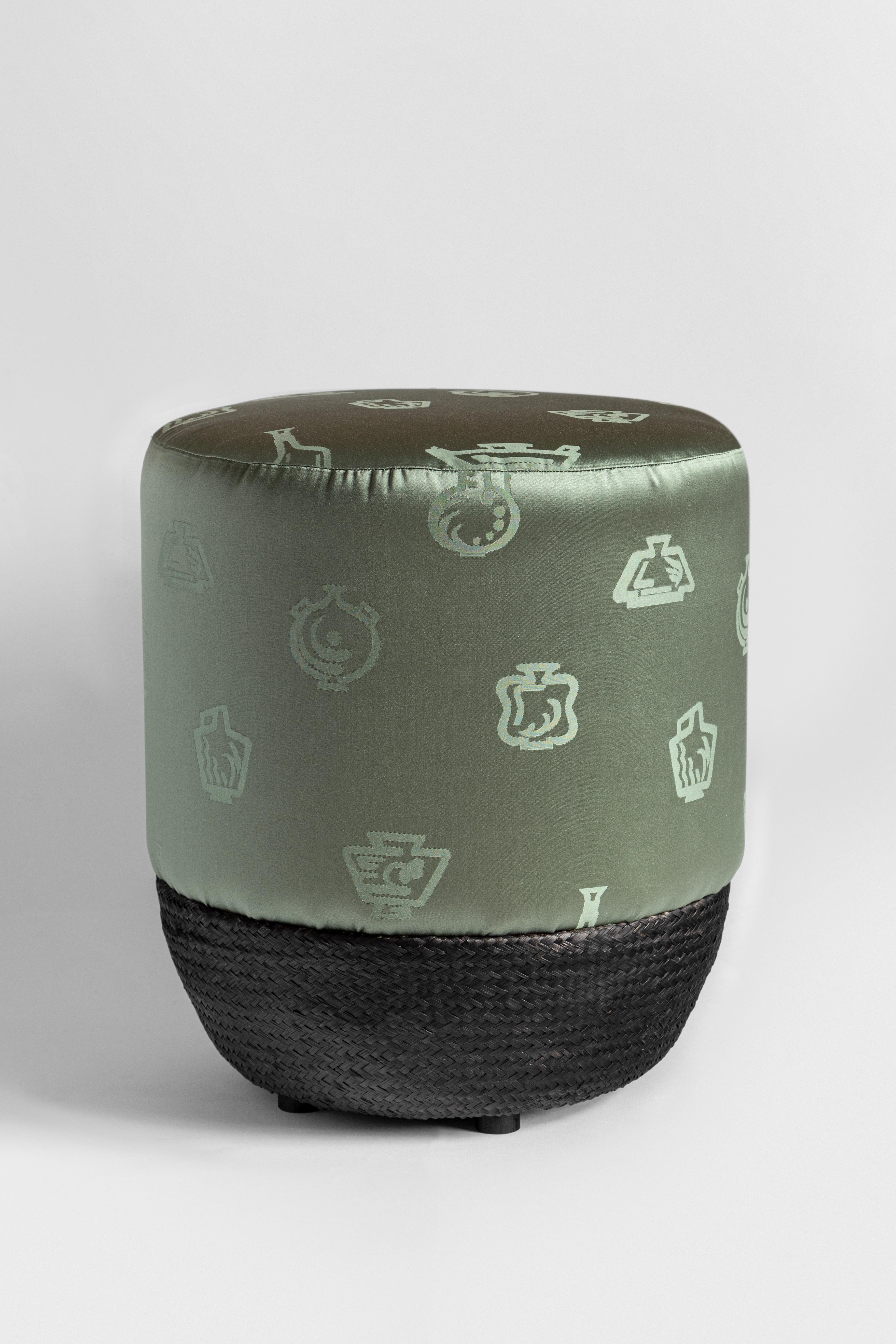 This sage-green pouf is made of two materials: a glossy, silk upholstered top embellished with a geometric print and a dark-hued, cotton-covered bottom intertwined to achieve the net-like texture. This comfortable yet timeless stool is one of Gio