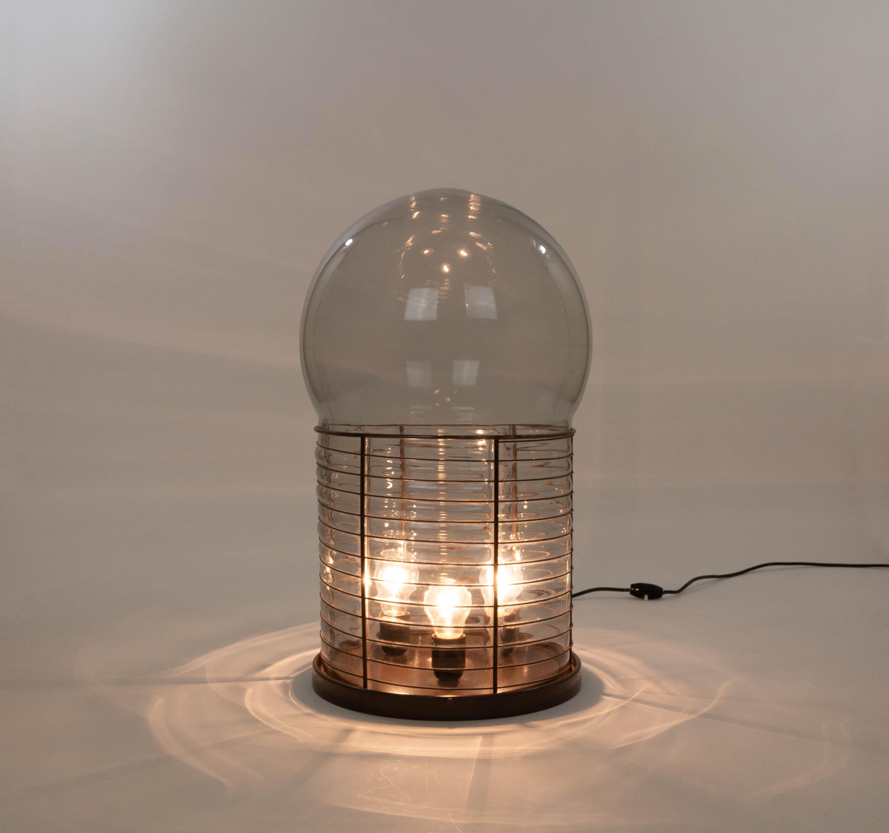 Alcinoo table lamp designed by Gae Aulenti and manufactured by Artemide in Italy in the 1970s..

The rather large lamp (60 cm / 24 in) is made of glass, blown into a metal framework. This gives a beautiful effect when the lamp is switched on. The