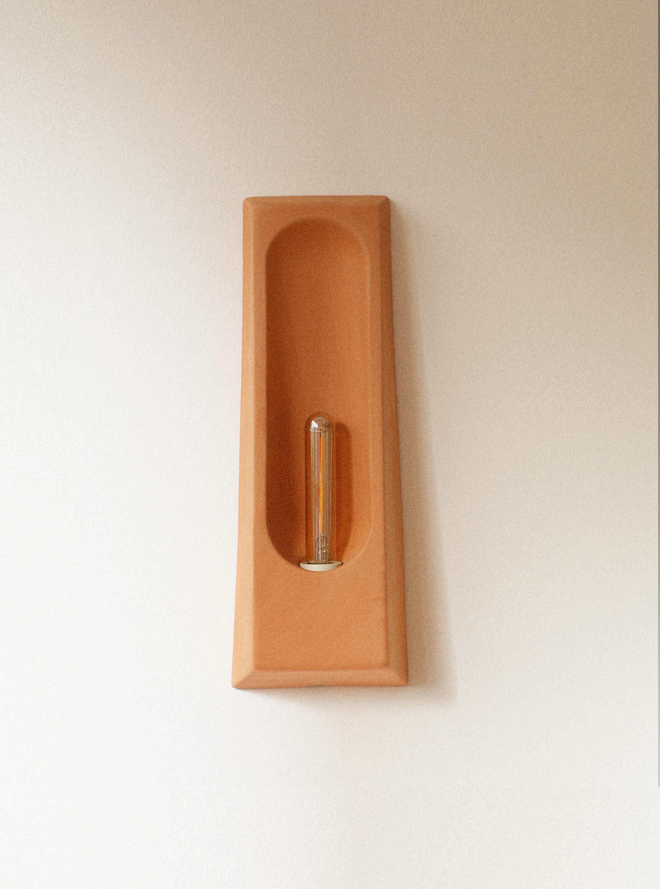Lámpara de pared Alcove Terra M de Violaine d'Harcourt
Dimensiones: P 7 x An 12 x Al 33 cm.
Materiales: Terracota.

Aplique fabricado en Portugal, bombilla incluida: LED E14 1W no regulable. Disponible en distintos acabados. Todas nuestras lámparas