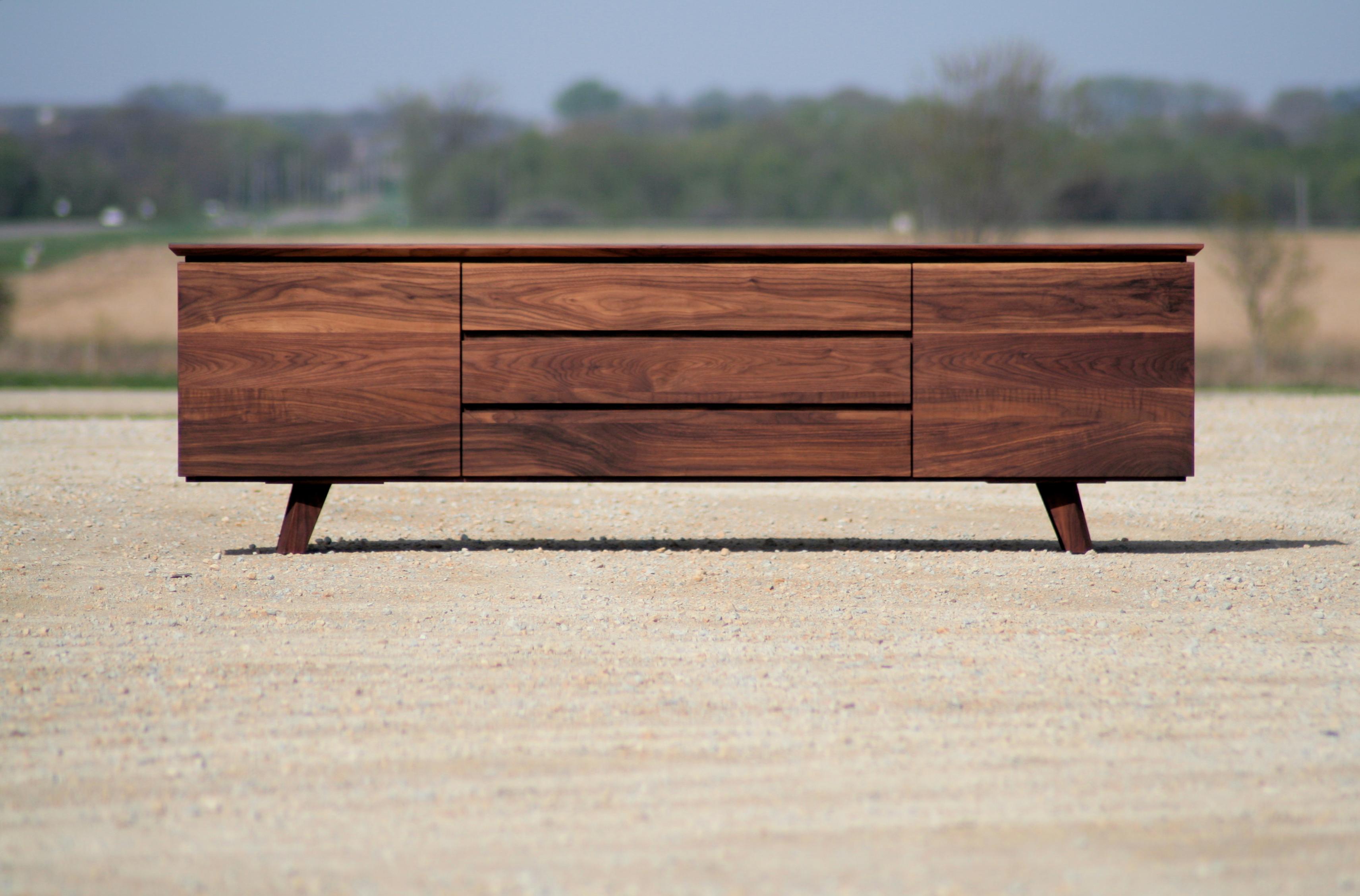 La ricca venatura del legno massiccio è il nostro elemento distintivo per questa credenza calda ed elegante. Il legno parla da solo nella credenza Alden, con le venature che scorrono senza soluzione di continuità sui frontali delle ante e dei