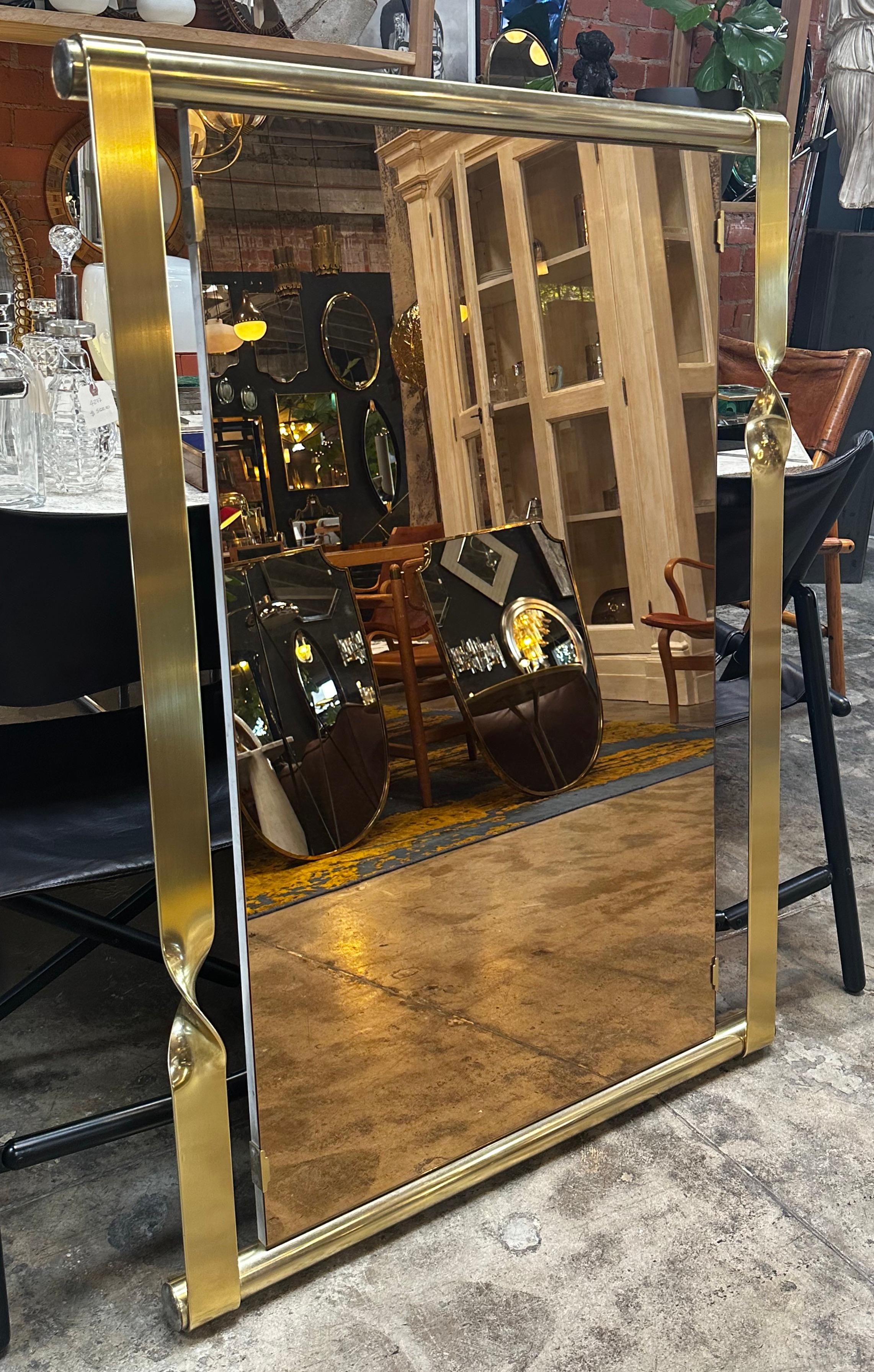 The rectangular mirror by Aldo Frigerio is an elegant and luxurious piece crafted entirely in brass. The mirror features a clean and Minimalist design, with a thin and sleek brass frame that surrounds the reflective surface. The rectangular shape of