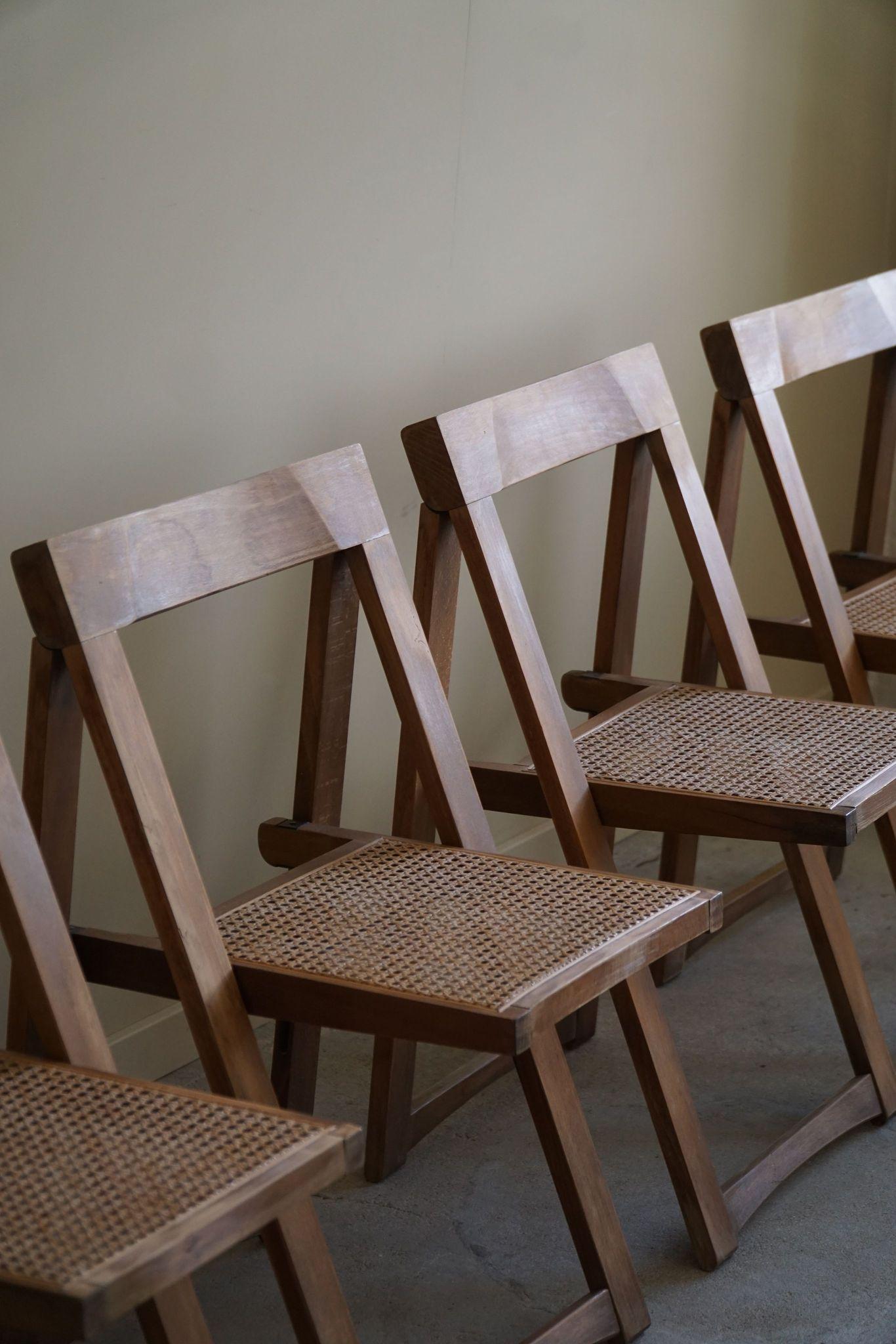Cet ensemble de quatre chaises pliantes vintage, conçu par Aldo Jacober pour Alberto Bazzini dans les années 1960, met en valeur l'élégance du design moderne italien du milieu du siècle dernier. Chaque chaise est dotée d'un cadre robuste en bois de