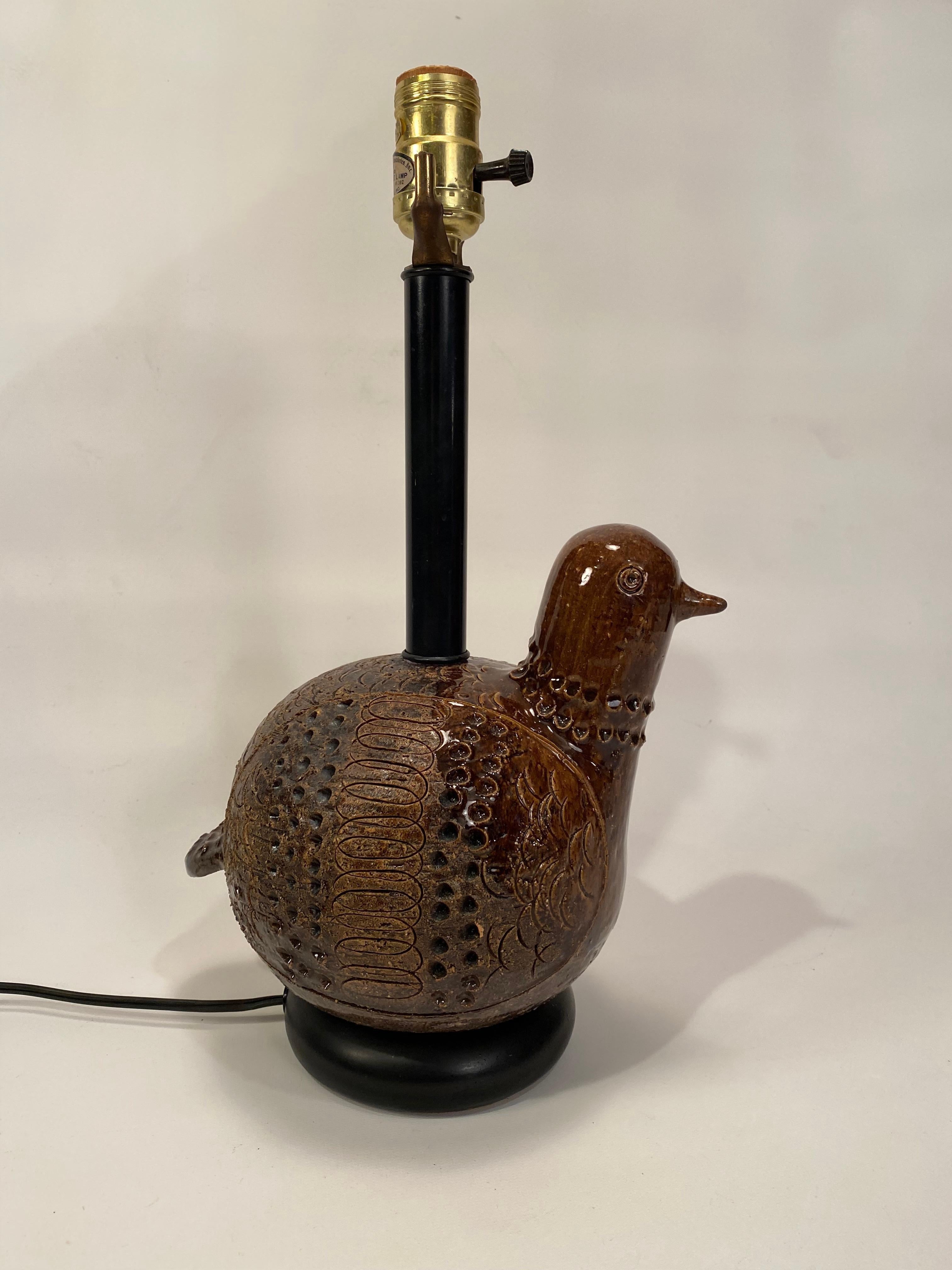 Aldo Londi Bitossi pottery bird lamp. Matte brown body with a gloss glazed head and tail feathers. Nice crisp carved and incised detail. Circa 1950-60. Good overall condition. No visible cracks or hairlines. Working wiring. Lamp hardware is original