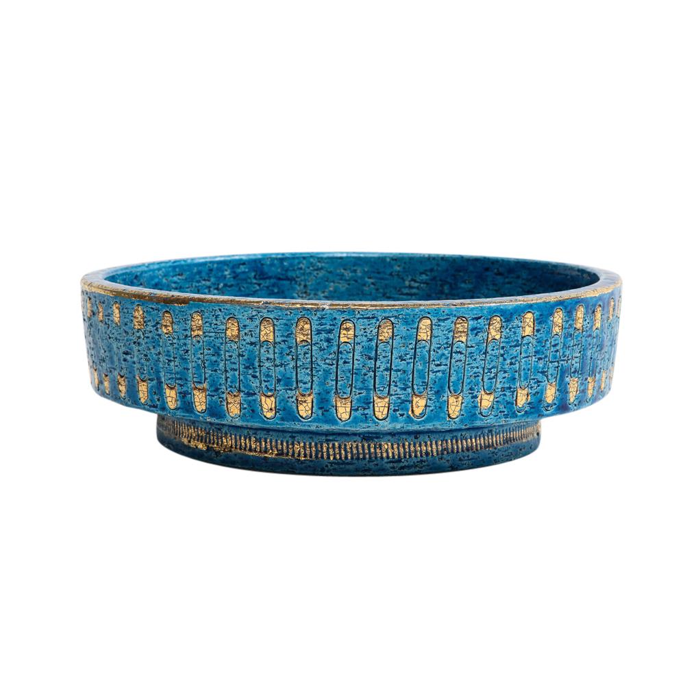 Bitossi bowl, ceramic, blue, gold, safety pin, signed. Medium scale circular bowl with footed base glazed in Rimini blue and decorated with a pattern of gold glazed safety pins on both the interior and exterior. Signed on the underside: 95/30 Italy.