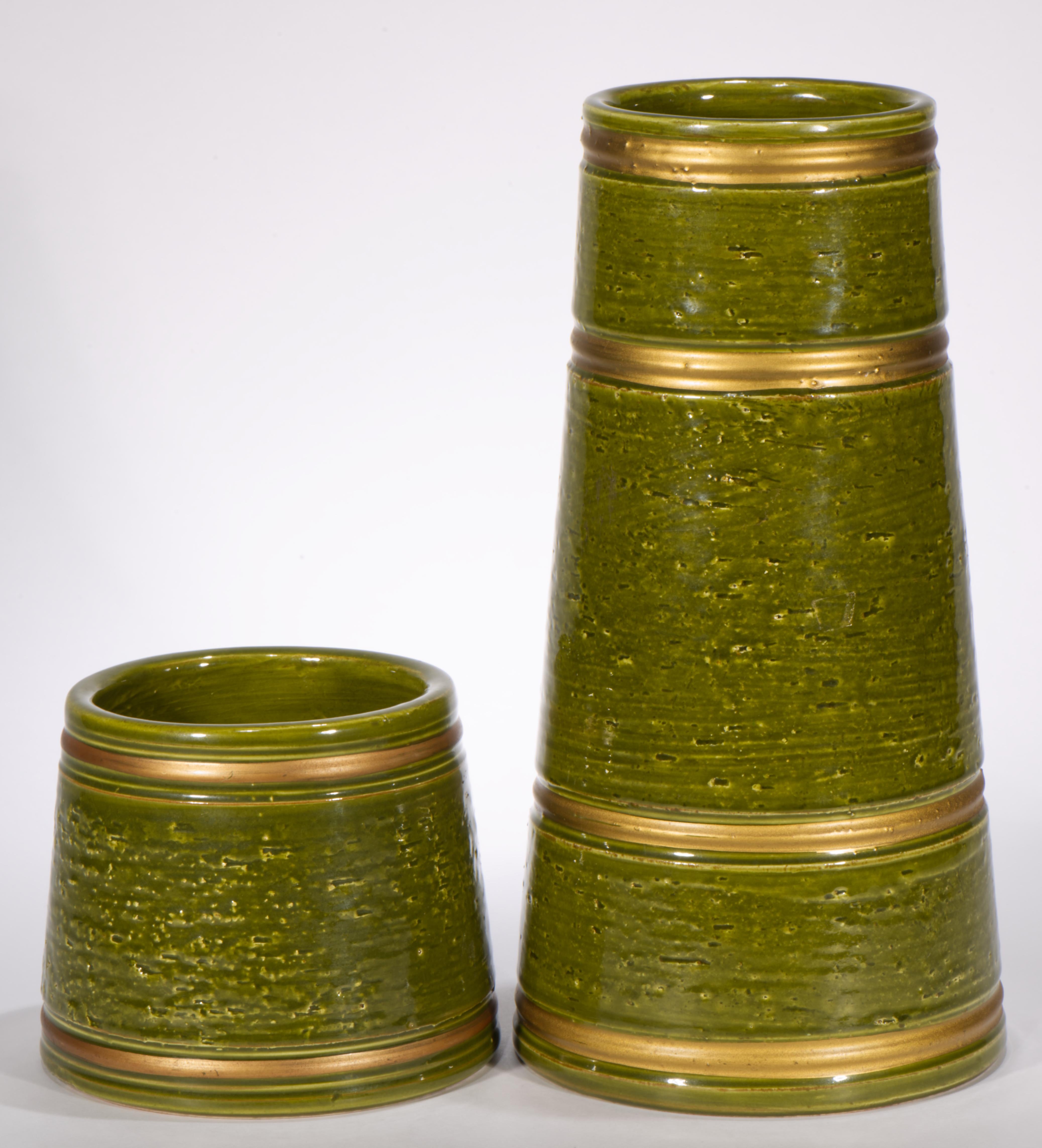  Il set di 2 vasi in maiolica vintage è stato disegnato da Aldo Londi e prodotto da Bitossi per Rosenthal Netter. I vasi affusolati e conici sono decorati con bande d'oro su uno sfondo verde oliva, che guidano l'occhio lungo le linee dei vasi e