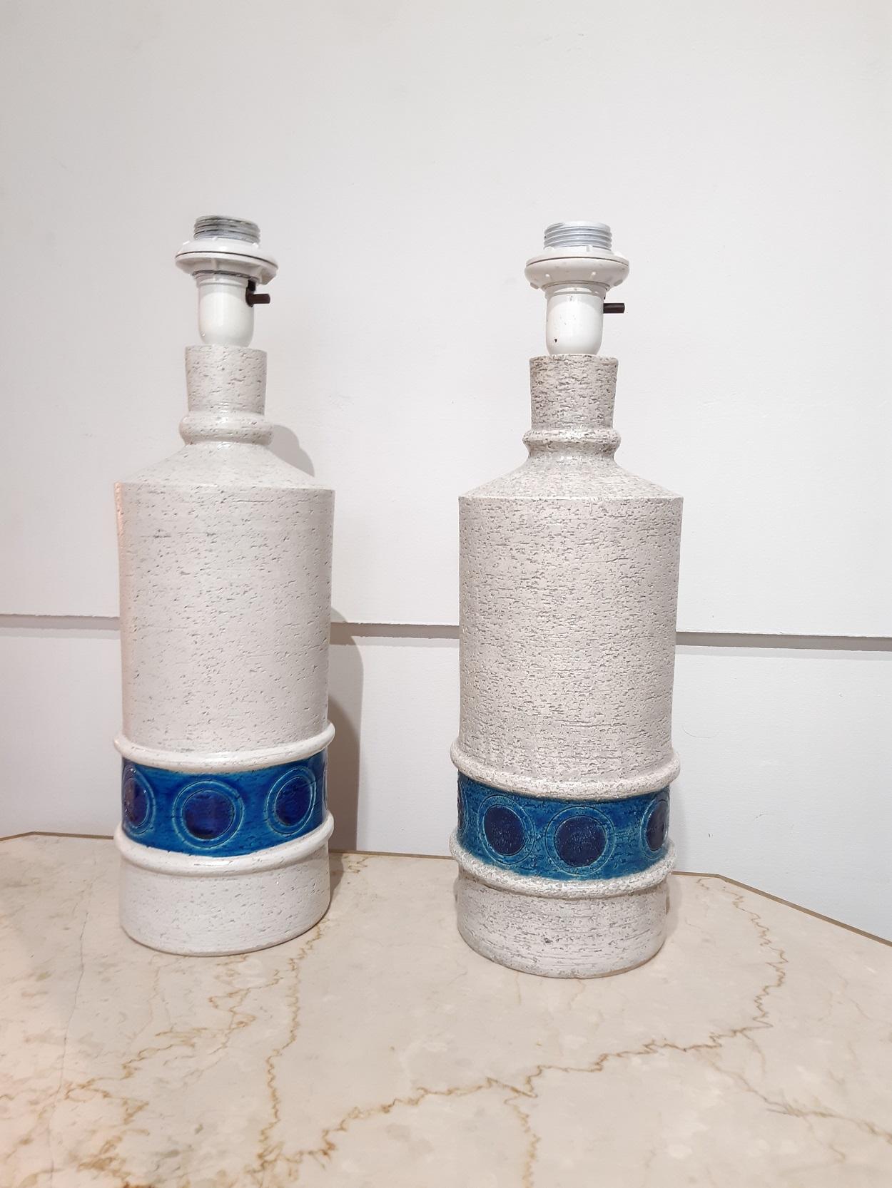 Aldo Londi Bitossi pair of Italian ceramic midcentury lamp

A pair of glazed ceramic table lamps in a textured, off-white color with a lower band of light and dark blues highlighting incised circular decorations.
Designed by Aldo Londi for the