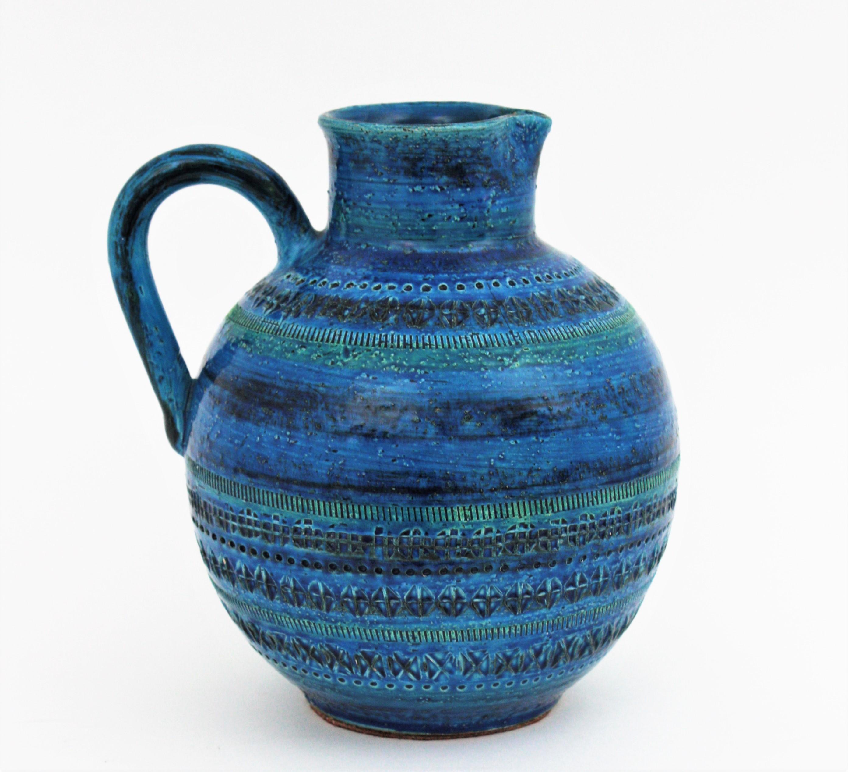 Unusual Mid-Century Modern blue glazed ceramic (Rimini Blu) large jug/ ball shaped pitcher, Italy, 1950-1960s.
Designed by Aldo Londi and manufactured by Bitossi. Handcrafted in Italy with hand carved geometric design in a glazed vibrant turquoise