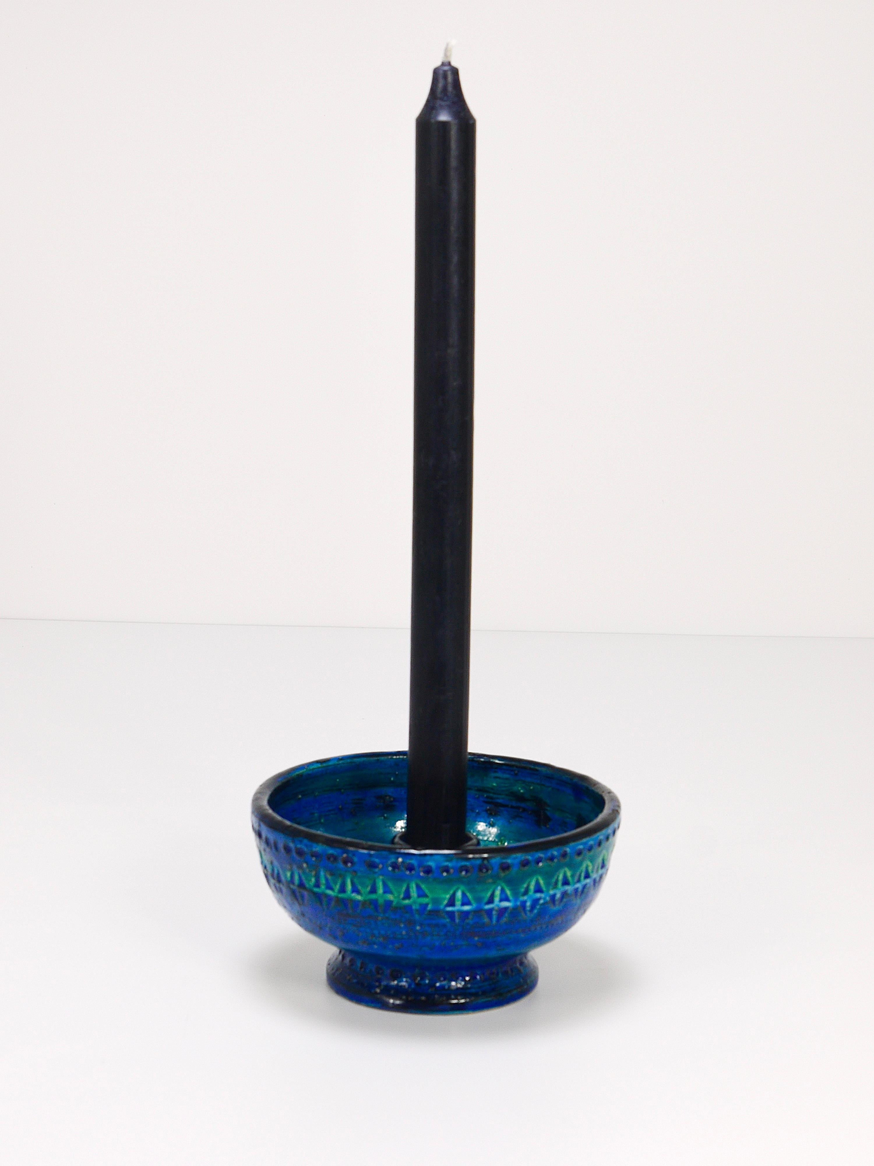 A beautiful and decorative midcentury Rimini blue glazed round candle holder or candlestick. Designed by Aldo Londi, manufactured by Bitossi Ceramiche / Italy in the 1950s. Handcrafted with hand carved geometric design in a glazed vibrant turquoise