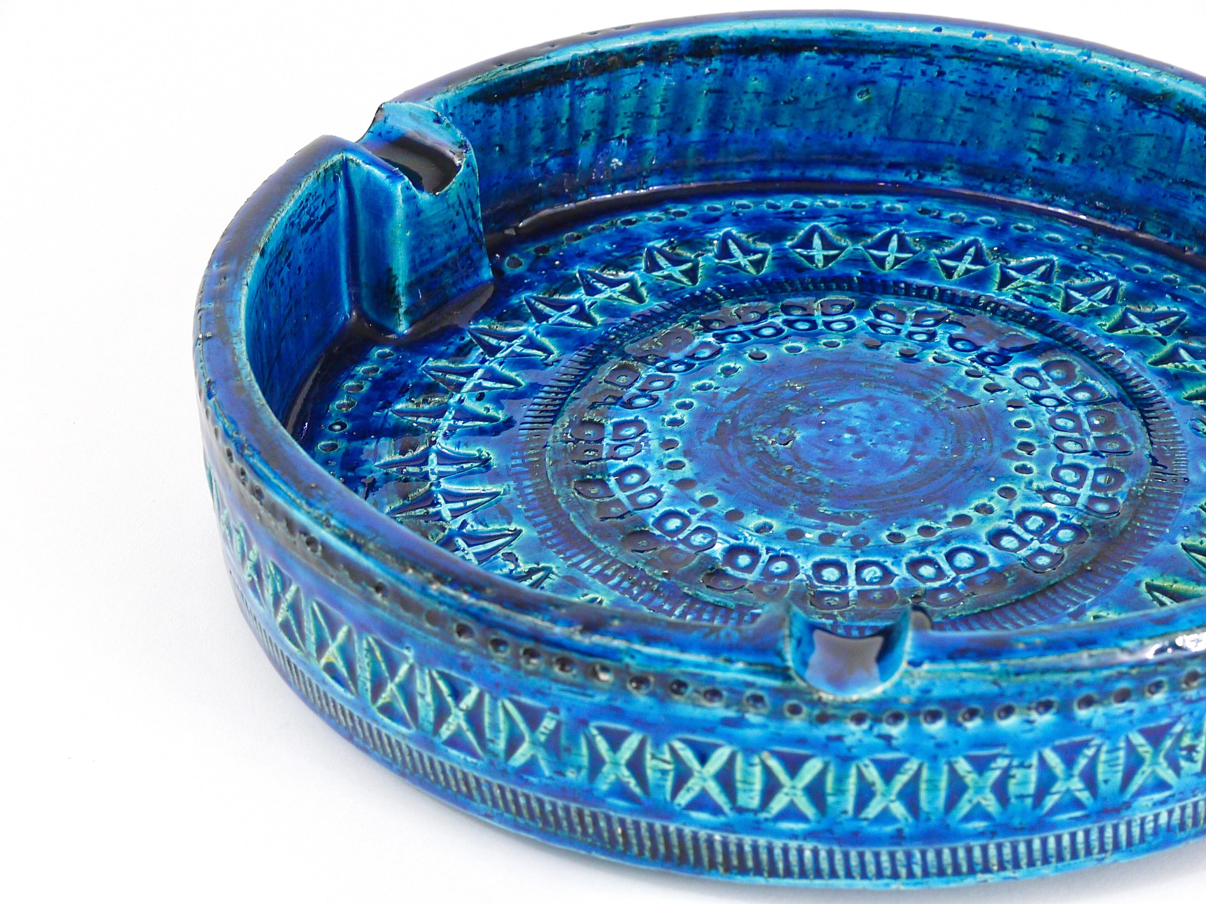 A beautiful, decorative midcentury Rimini blue glazed ashtray. Very large, has a diameter of 9 1/2 inches, Designed by Aldo Londi, manufactured by Bitossi Ceramiche / Italy in the 1950s. Handcrafted with hand carved geometric design in a glazed