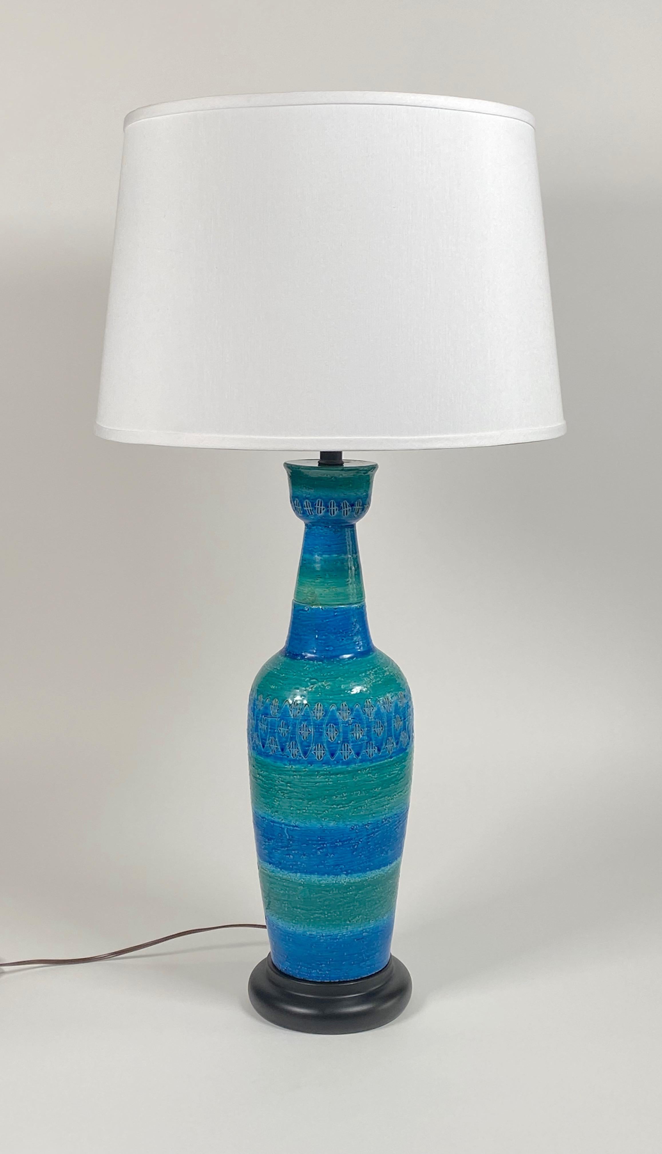Ceramic table lamp designed by Aldo Londi for Bitossi of Italy. Multi-colored in green and blue with impressed patterns around the body of the lamp, resting on a black metal base, rewired and the metal components resprayed. The lamp height of 24' is