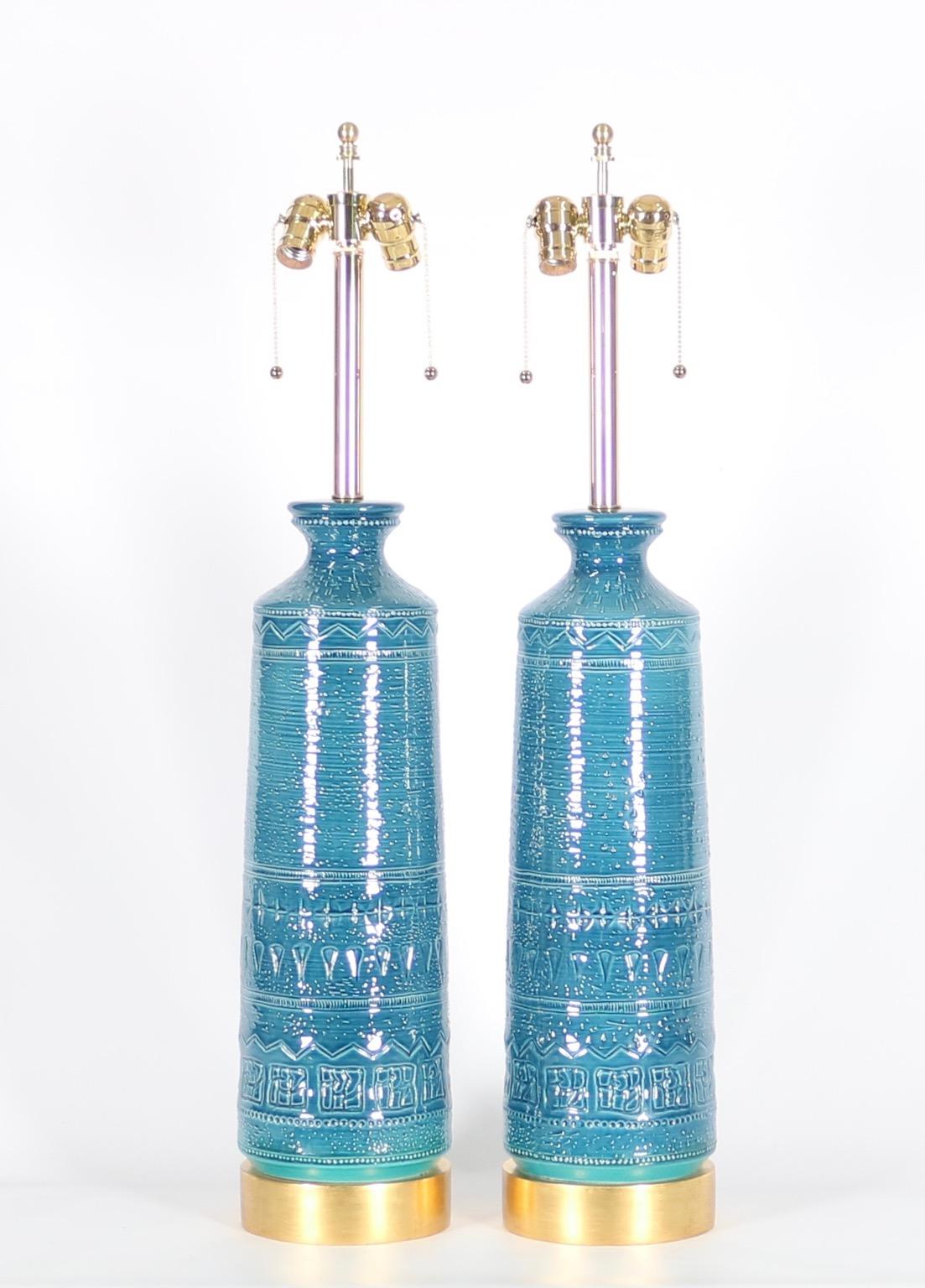 Hollywood Regency Bitossi style pair of table lamps in carved ceramic with blue & aqua glaze, mounted on gilt wooden bases. The pair was designed in the 1960s in Italy and is in great vintage condition with age-appropriate wear. Fully restored with