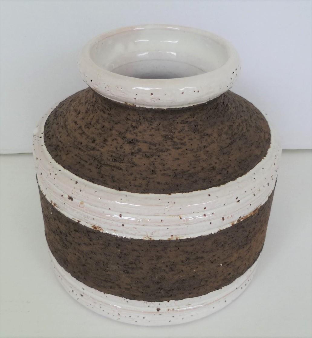 Striking Italian Mid-Century Modern vase by Aldo Londi for Bitossi and imported by Raymor in the 1960s. With a circular squat body, it has a a predominate rough textured cork like finish with circular divisions of white glaze around the body and