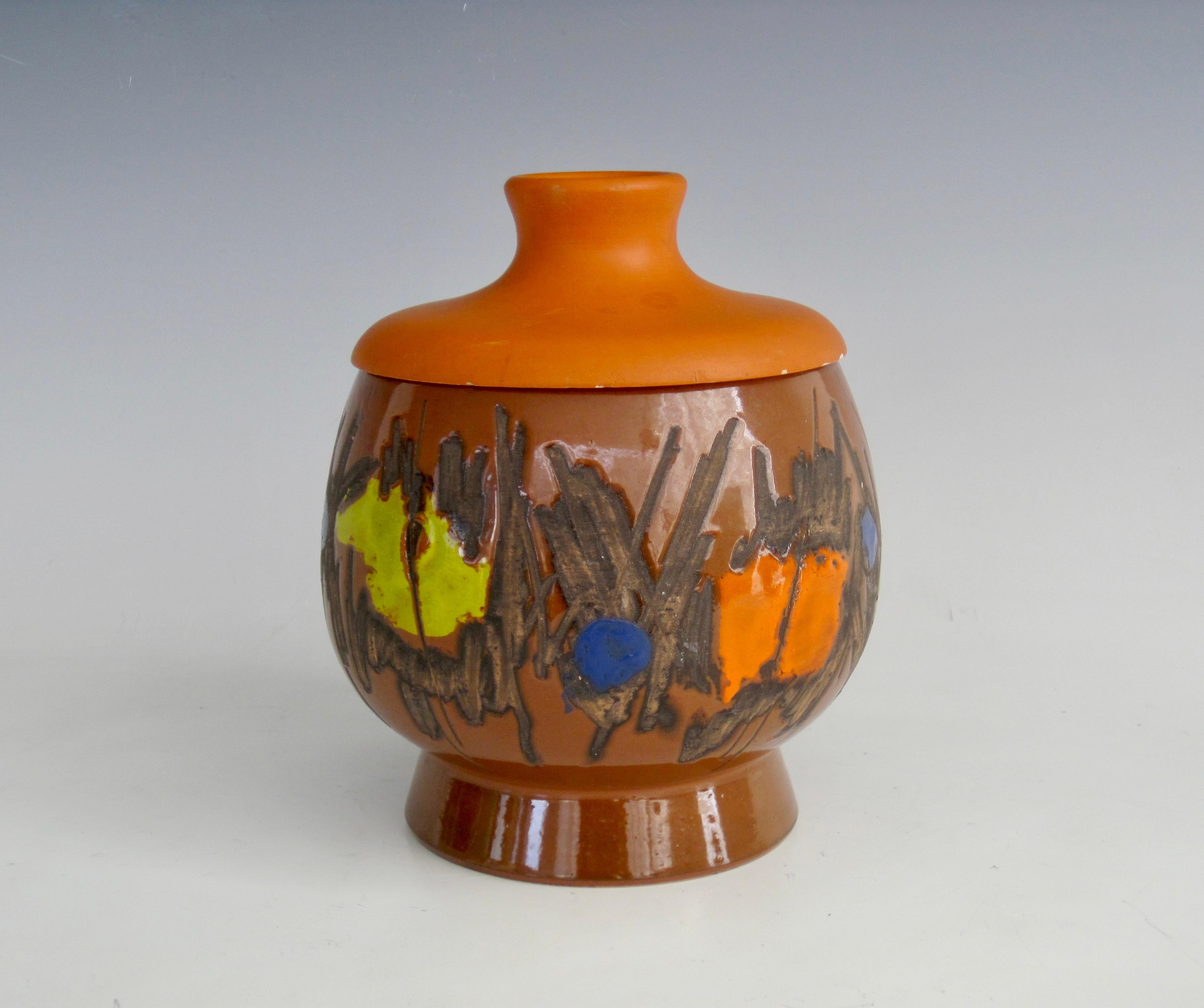 Bitossi for Raymor rare model 7549 pedestal lidded jar, in earth tones with bright pops of color and sgraffito style. The painted wooden lid has Denmark incised on underside.
Signed 7549 A Italy with Raymor label intact on underside.