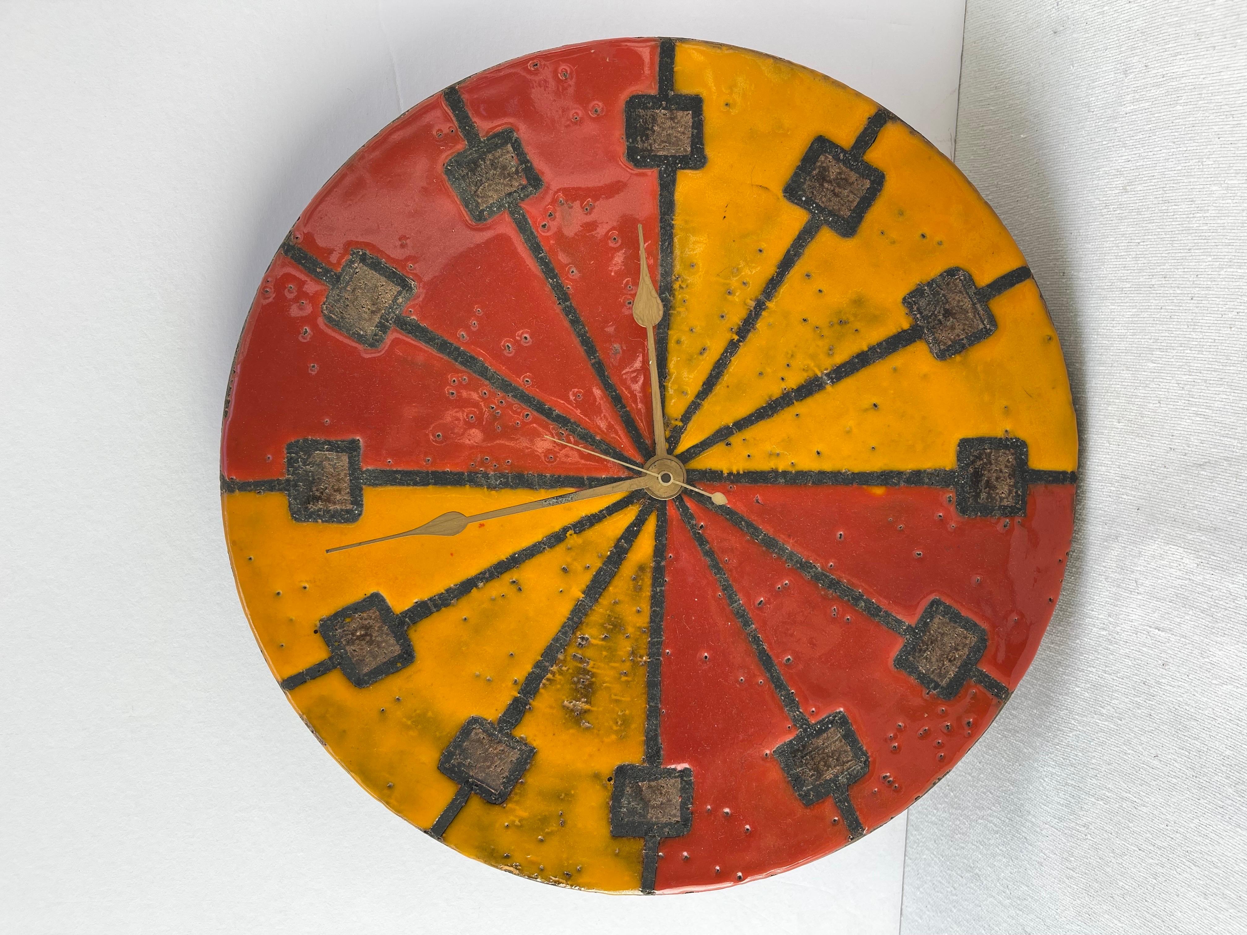 Aldo Londi for Bitossi Mid Century Ceramic Wall Clock. Manufactured by Howard Miller the American designer. The ceramic face was designed by Bitossi and features a red/orange and yellow glazed finish over brown stoneware. Tis modernist Meridian