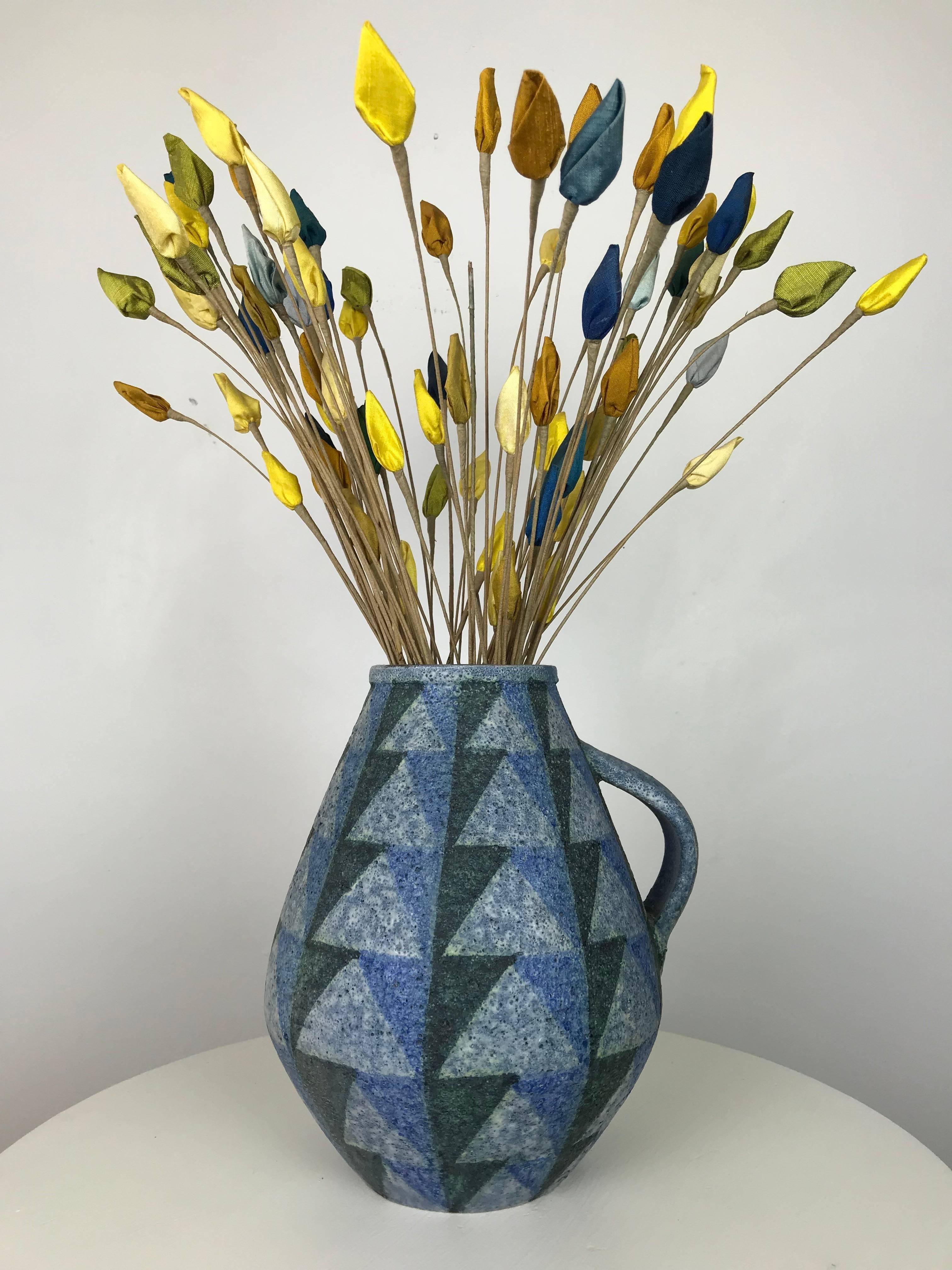 I've used this beautiful display in my residence for years, and it came together when I found a lesser vase at a Mid-Century Modern estate, and they contained these vintage modernist flowers made of fabric wrapped wood, and married them with this