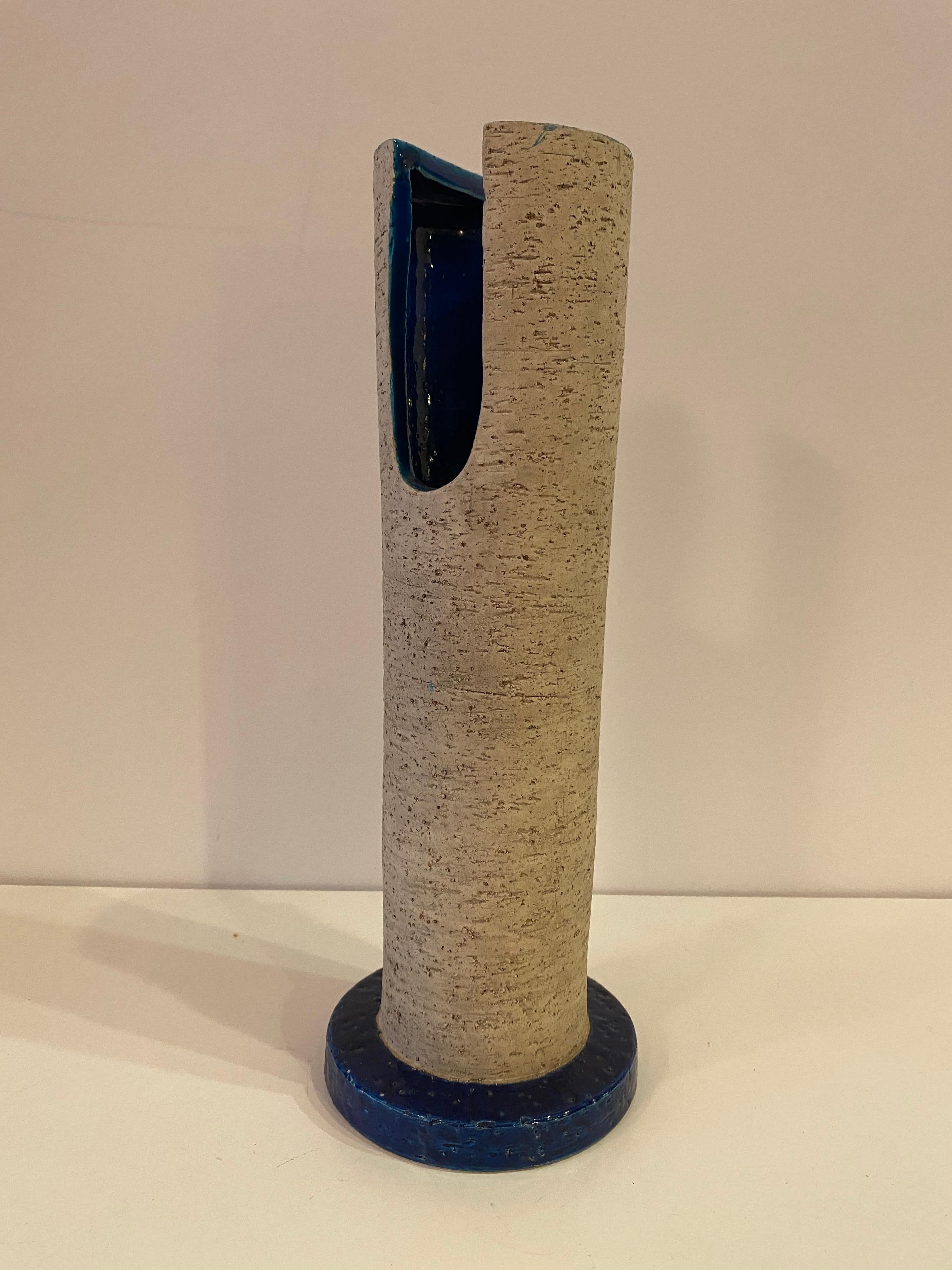 Aldo Londi for Raymor Ceramic 13.5 tall vase. Unusual design with cut out sections toward top of Cylinder. Blue Glaze on inside and bottom rim. Vase retains its original Raymor label.