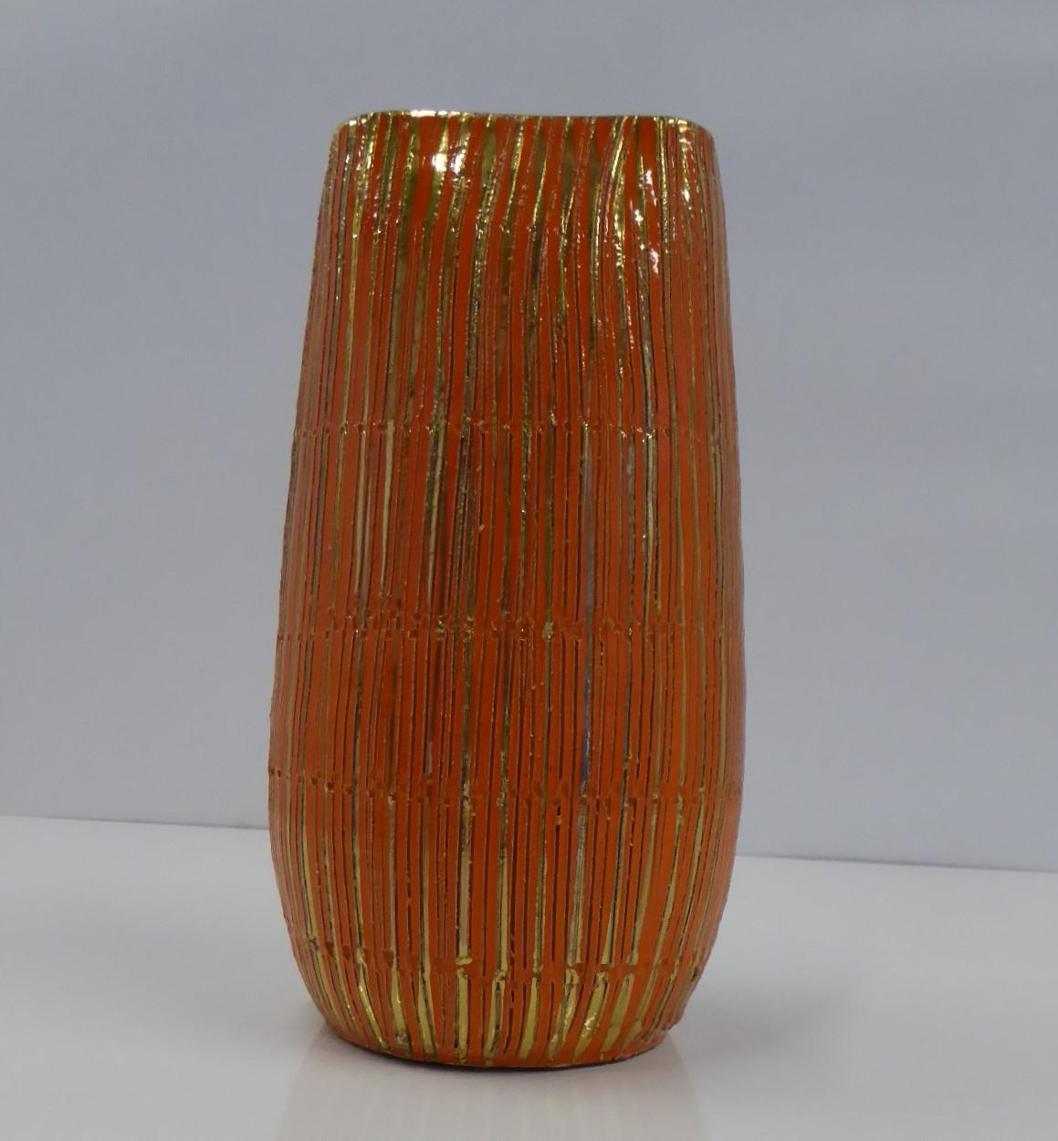One of Aldo Londi's midcentury creations, his SETA (Silk) Series of Sgraffito Pottery for Bitossi in fun vibrant orange glaze and gold gilt. A lovely handmade striated vase with bands incised with small uneven shapes. The gold gilt stripes have been