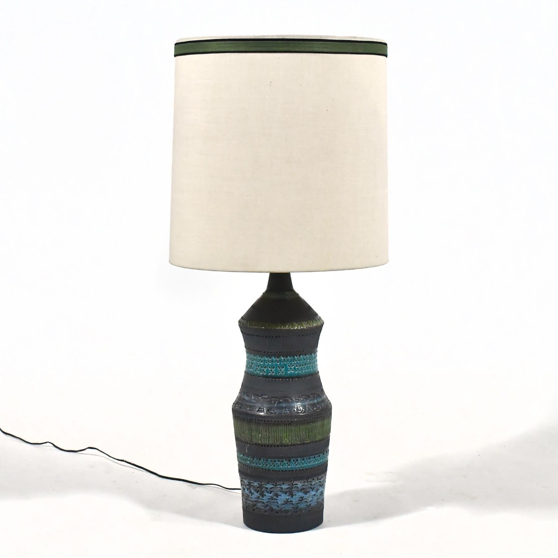 Esta lámpara de sobremesa, un bello ejemplo de la cerámica Bitossi, tiene la base cubierta de bandas con la decoración característica de Londi en verde apagado, azul y esmalte carbón mate. Conserva su tonalidad original.

 Total: 37 
