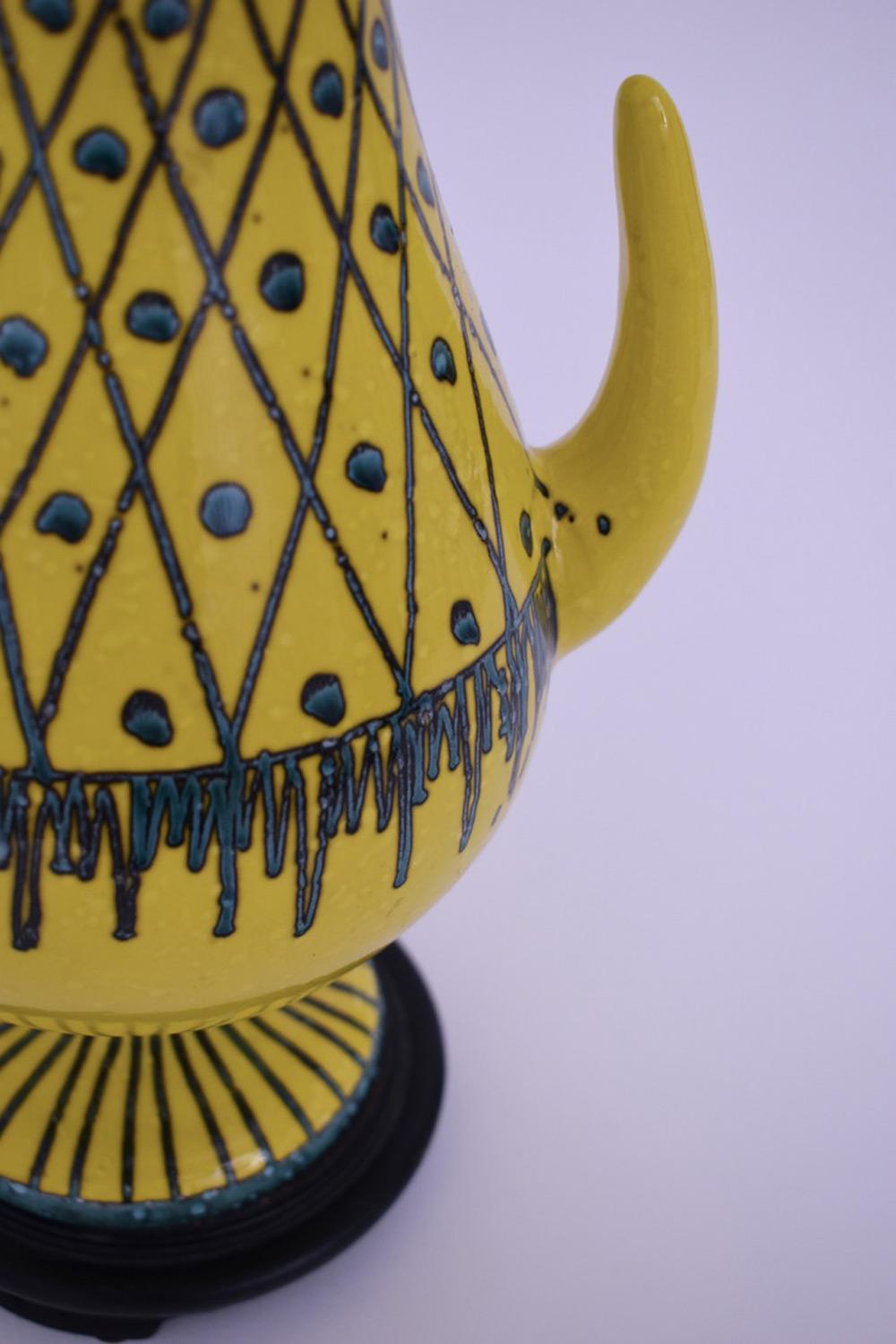 Ceramic yellow table lamp with geometric pattern and two horns on the sides. 