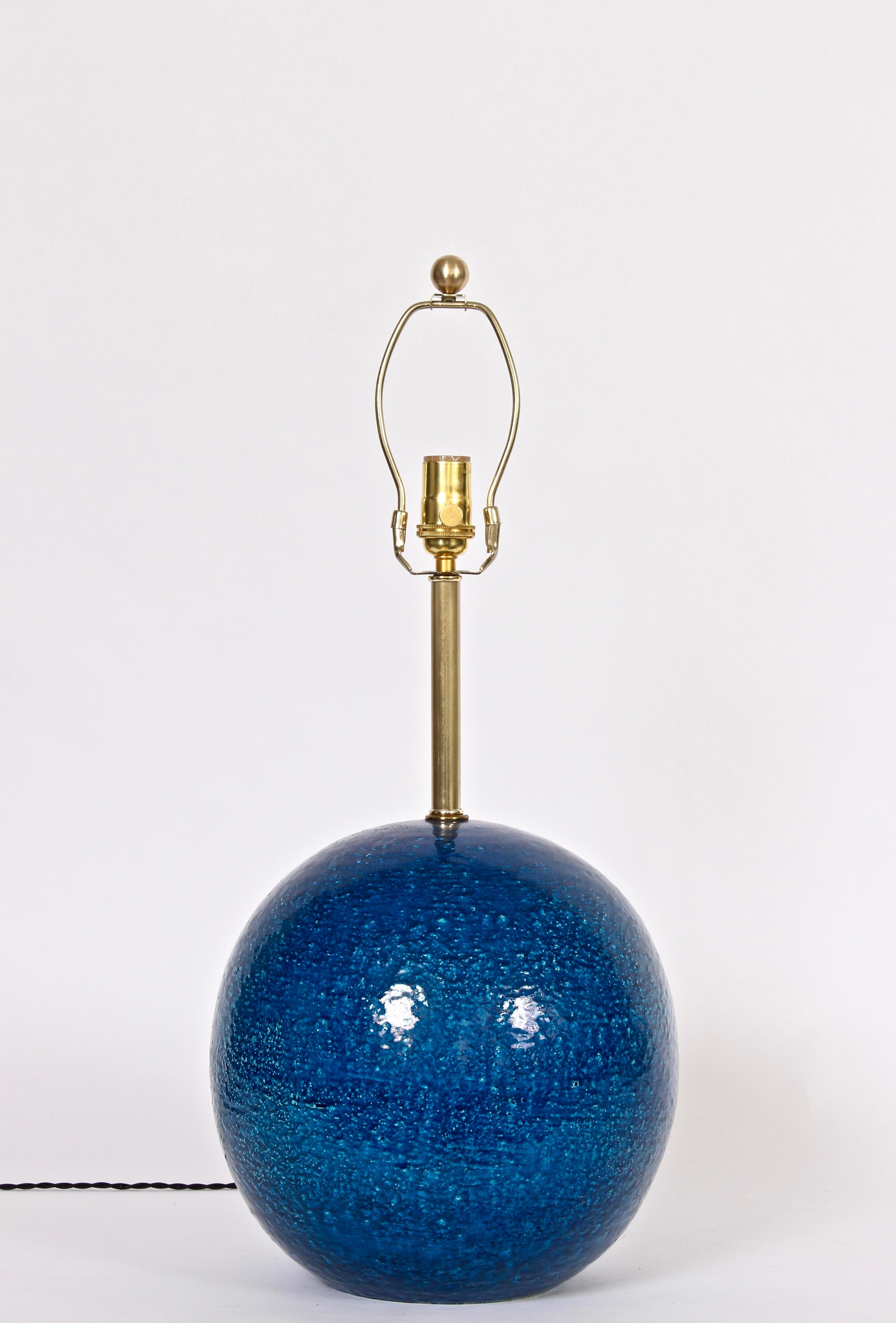 Italian Modern Aldo Londi for Bitossi cobalt blue textured globe table lamp. Featuring a handcrafted coarse ball form with brilliant Royal blue coloration and reflective glaze. Distributed by Raymor. Lampshade shown for display only and not for sale