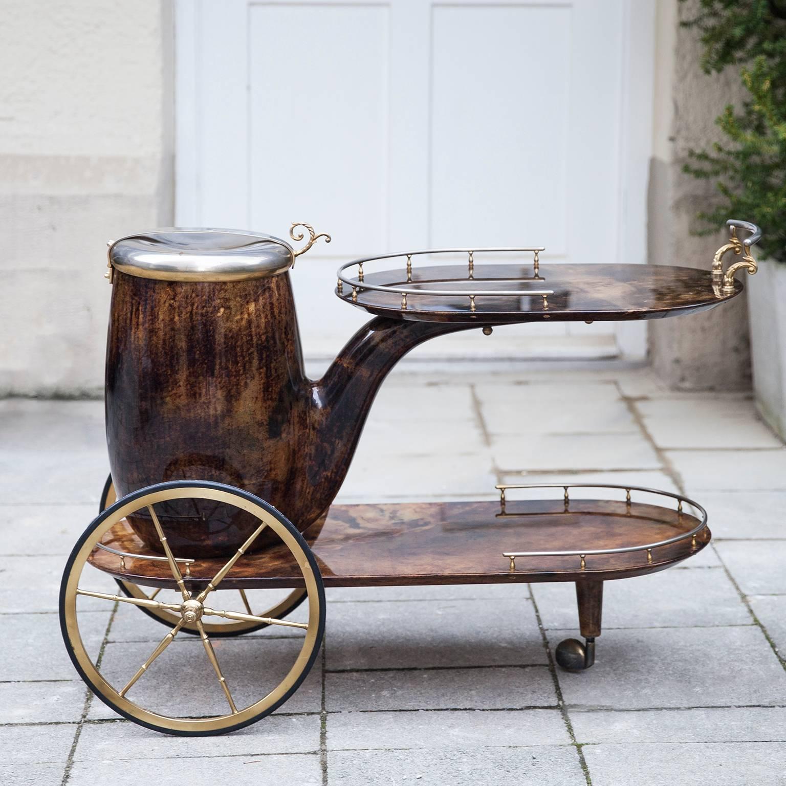 Aldo Tura bar cart in form of a pipe, lacquered in brown goatskin with brass applications and a huge container as champagne or wine cooler.
Excellent condition.