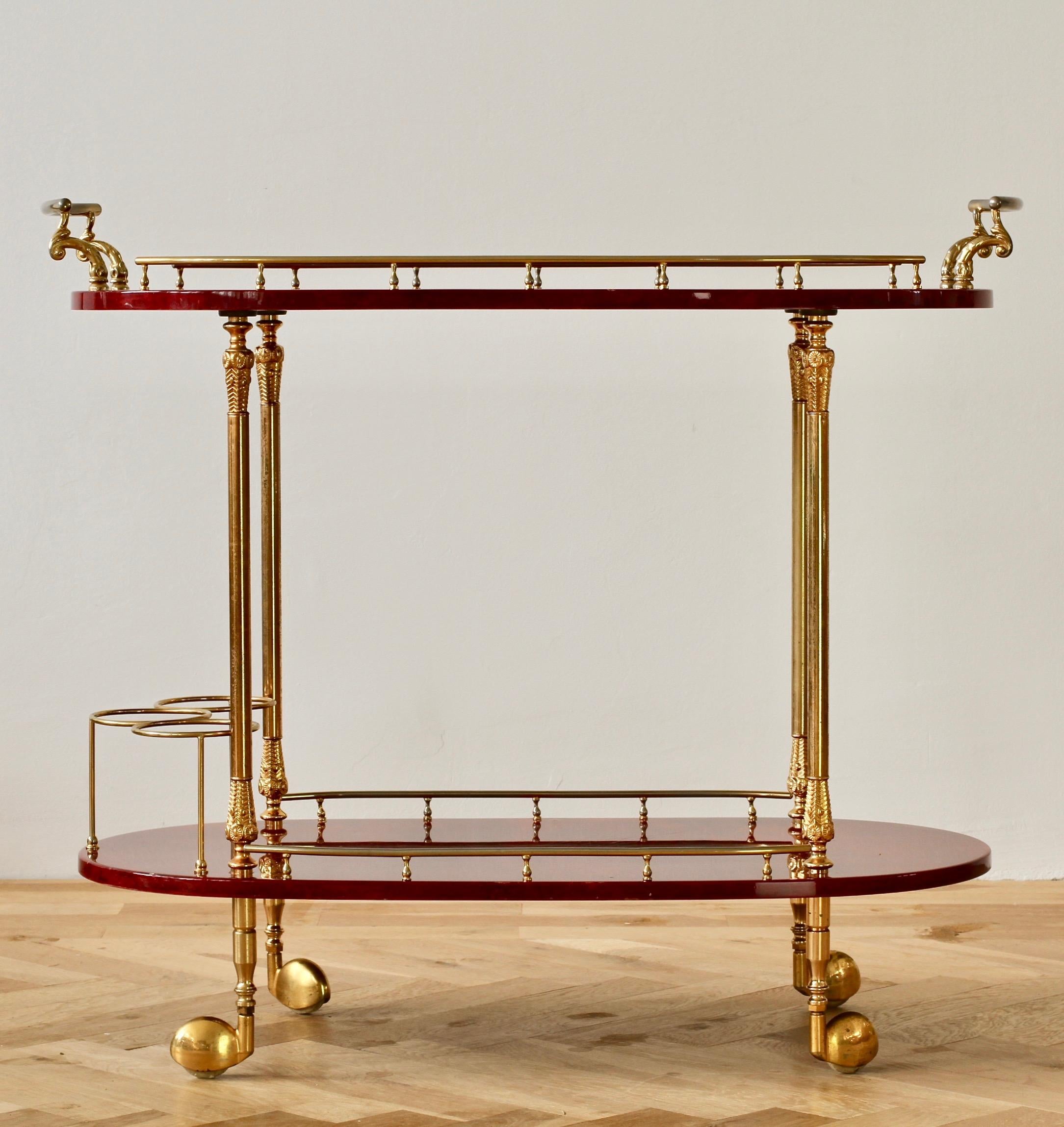 Midcentury Italian 1950s bar cart, tea trolley or drinks stand by Aldo Tura, Milan. The red colored and lacquered goatskin leather combined with gilded cast metal handles, rails and finals is perfect for any Mid-Century or Hollywood Regency