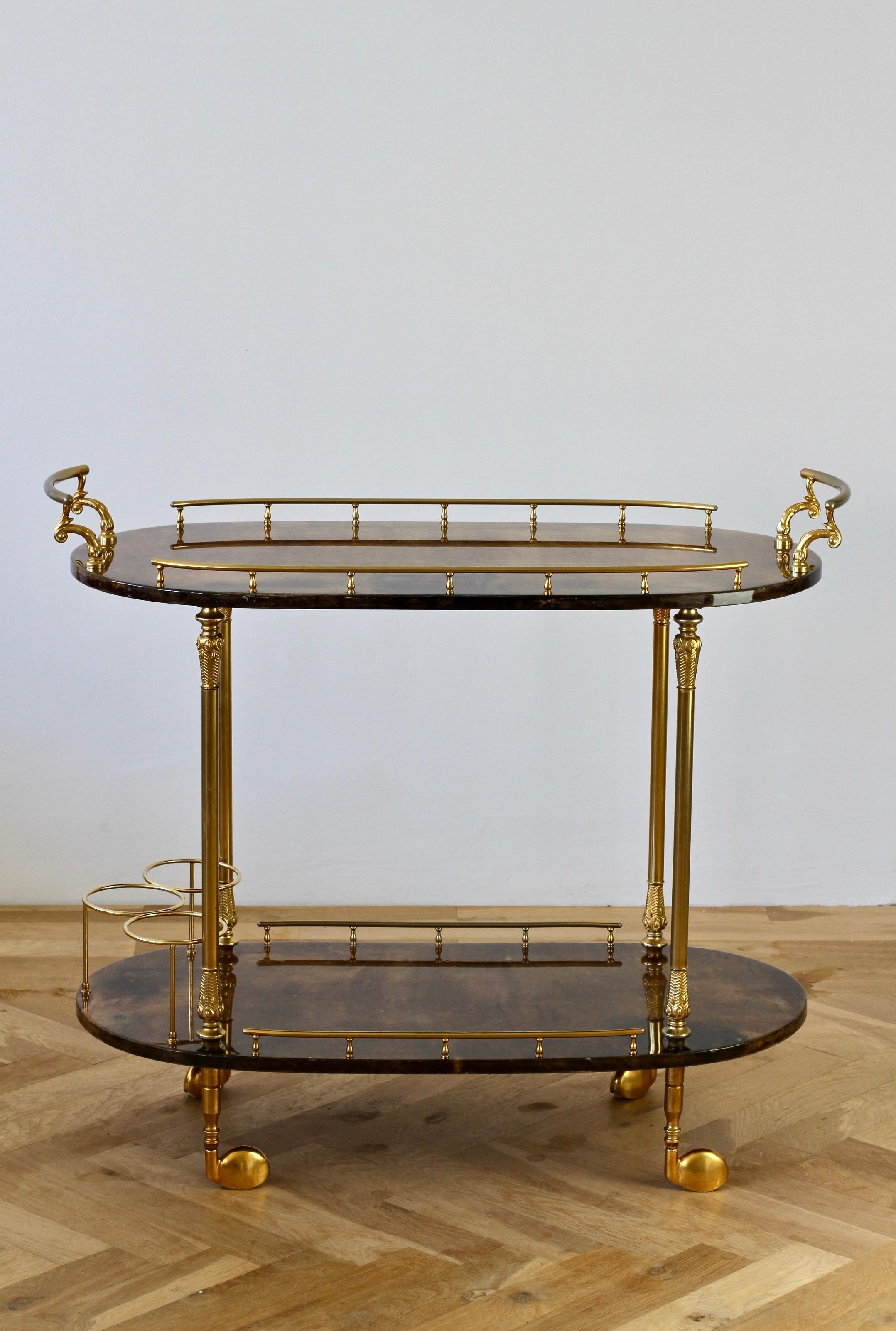 Large midcentury Italian 1950s bar cart, tea trolley or drinks stand by Aldo Tura, Milan. The brown colored and lacquered goatskin leather combined with gilded cast metal handles, rails and finals is perfect for any Mid-Century or Hollywood Regency