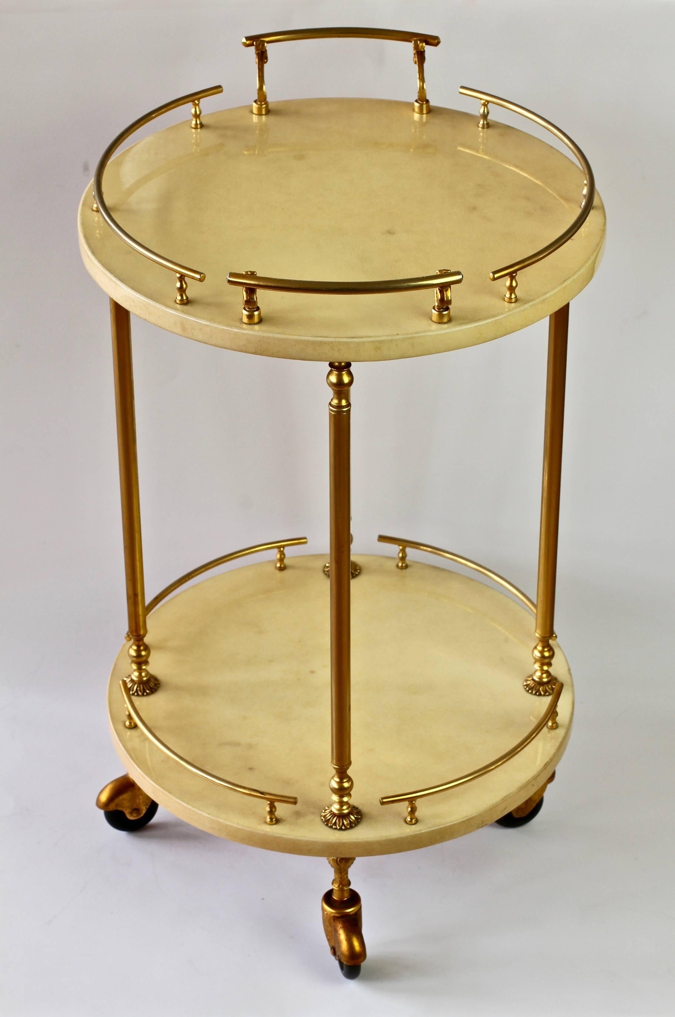 Petite circular Italian 1950s bar cart, drinks trolley by Aldo Tura, Milan. Beautiful cream colored and lacquered goatskin leather combined with gilded cast metal handles, rails and finals.

Although no 'Tura Milano' label is present - we are