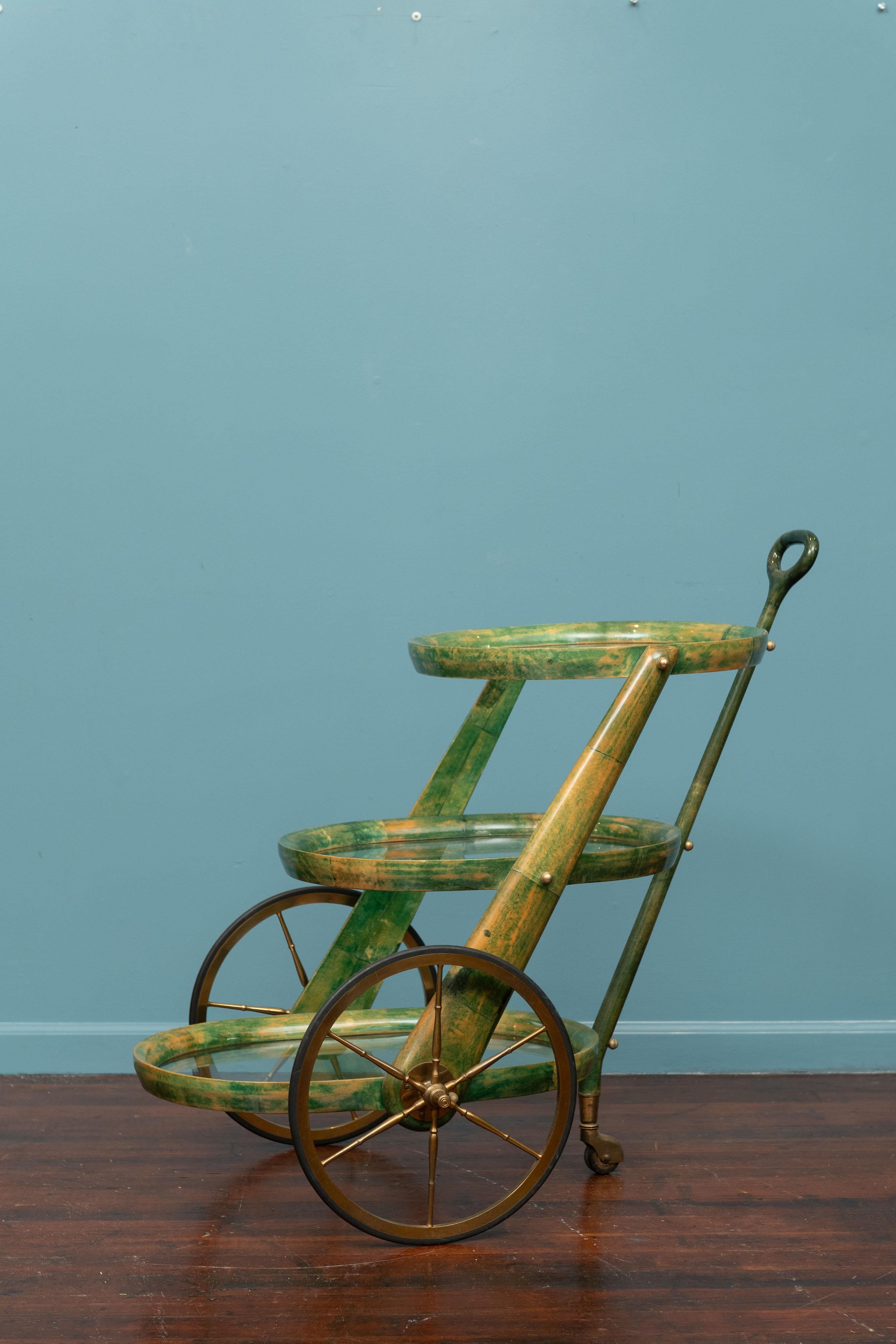 Aldo Tura parchment bar cart or trolley, Italy. Three oval tiered trays for glassware and bottles on rolling wheels. An eye catching design in the rarer jade colored parchment with brass finials and hardware.
 In very good original condition, it is