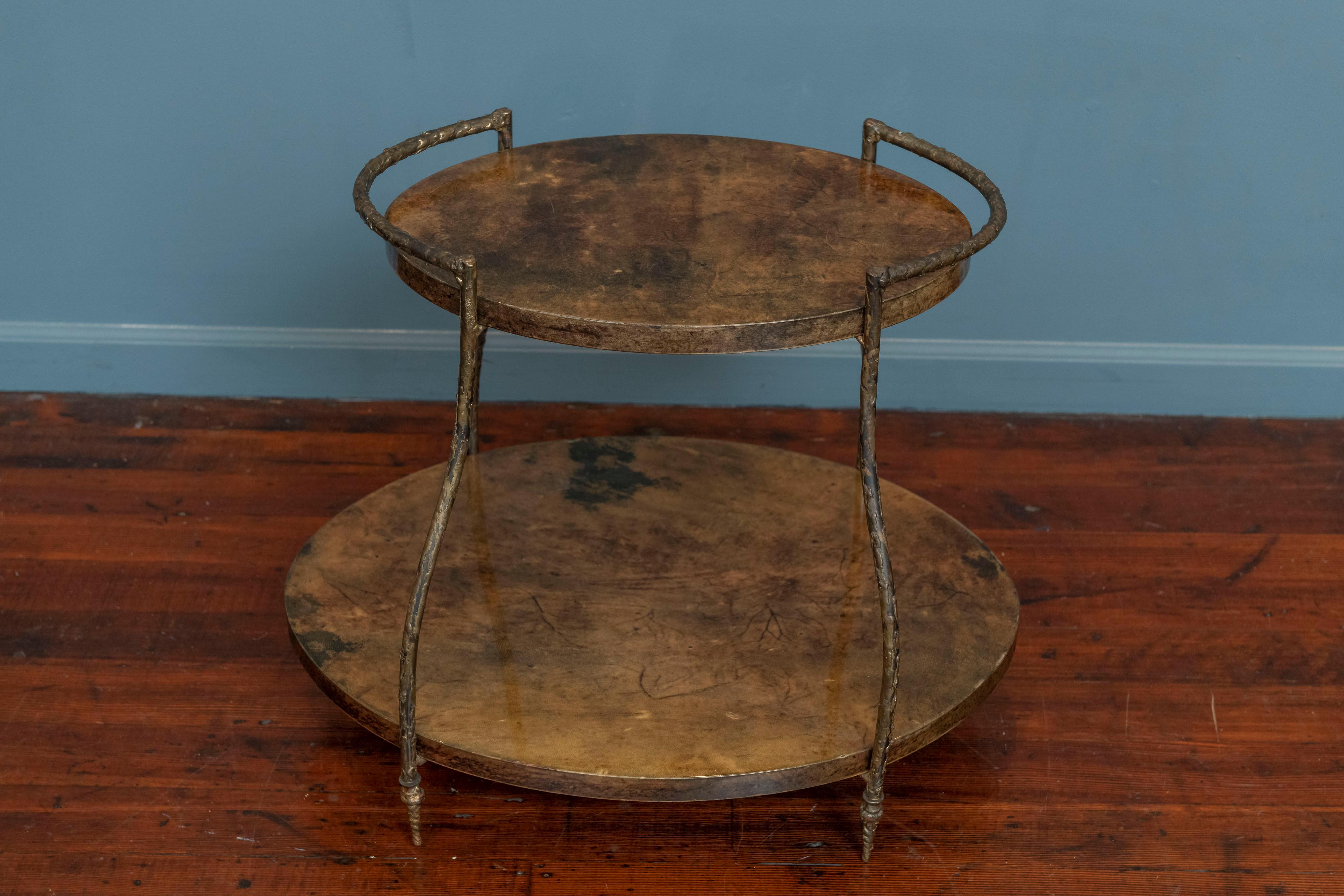Aldo Tura bar cart or drinks table made from faux marbleized goatskin wrapped wooden oval tops with an unusual prickly bronze finish frame, labeled. Rare design win very good original condition with one small chip to edge of lower shelf.