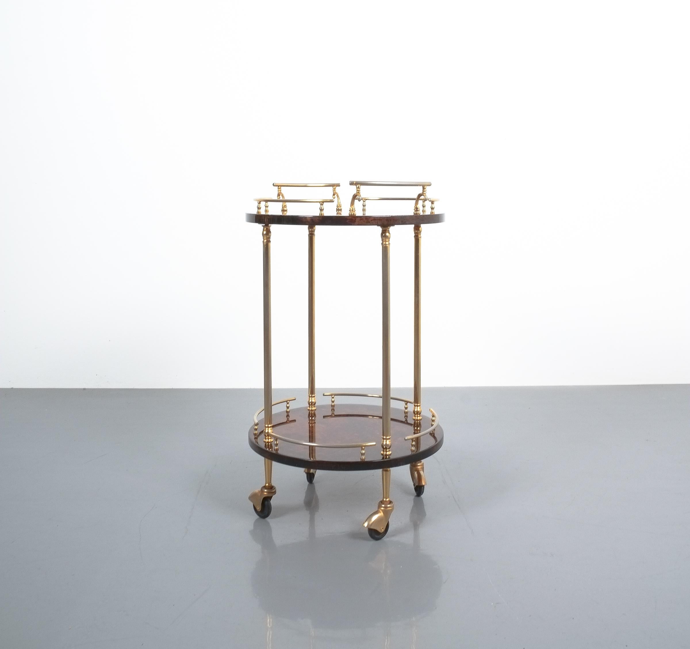 Petite liquor or bar cart by Aldo Tura Milan, Italy. It's composed of two dyed and lacquered parchment trays and brass hardware and it's in very good condition. Minimal, very superficial traces of use are visible.