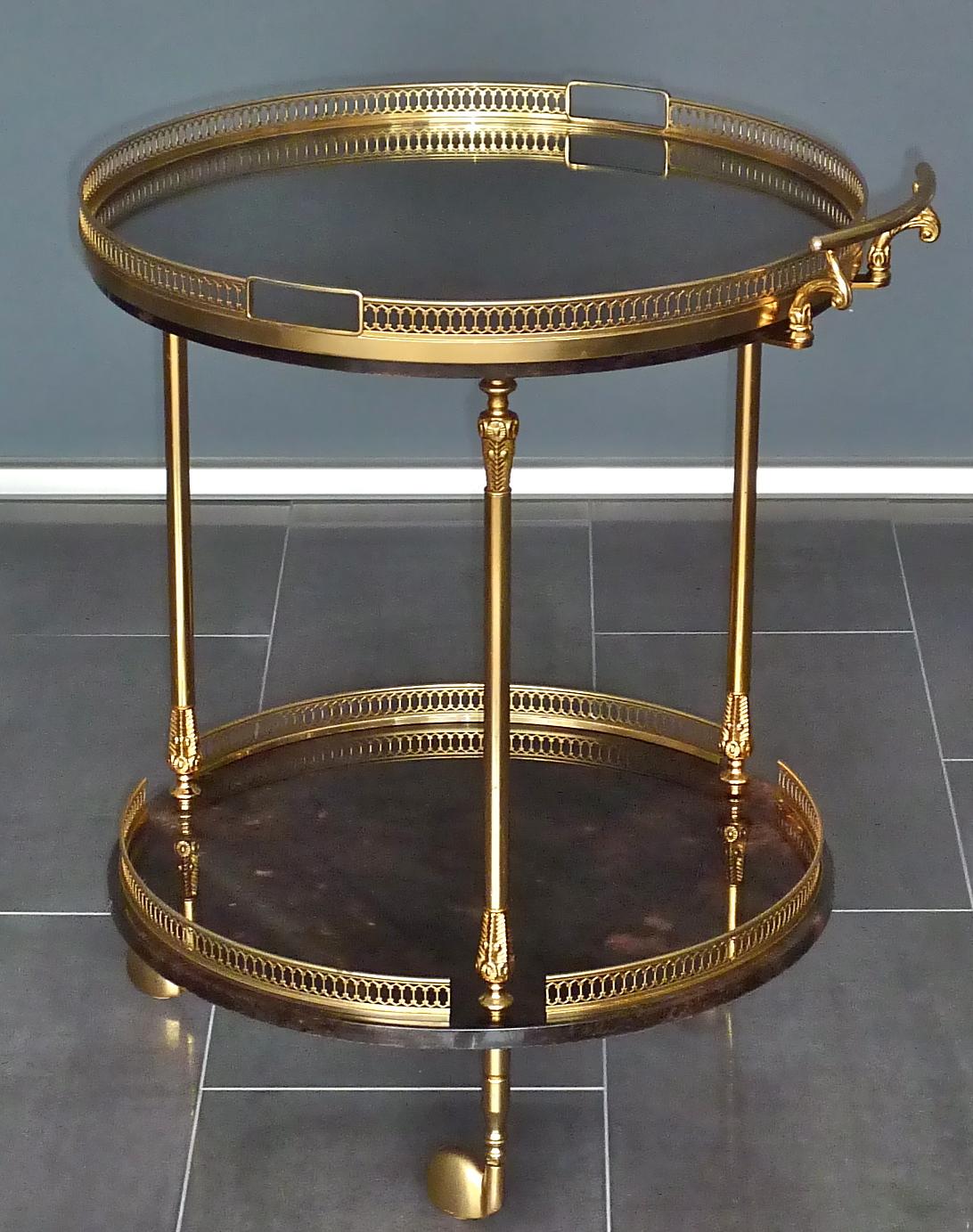 Noble and elegant Aldo Tura gilt brass serving table with tray, Italy around 1958. Made of dark brown to lighter brown color, partially pinkish spots lacquered and dyed goatskin or parchment this 2-tier bar cart or drinks trolley on three castors