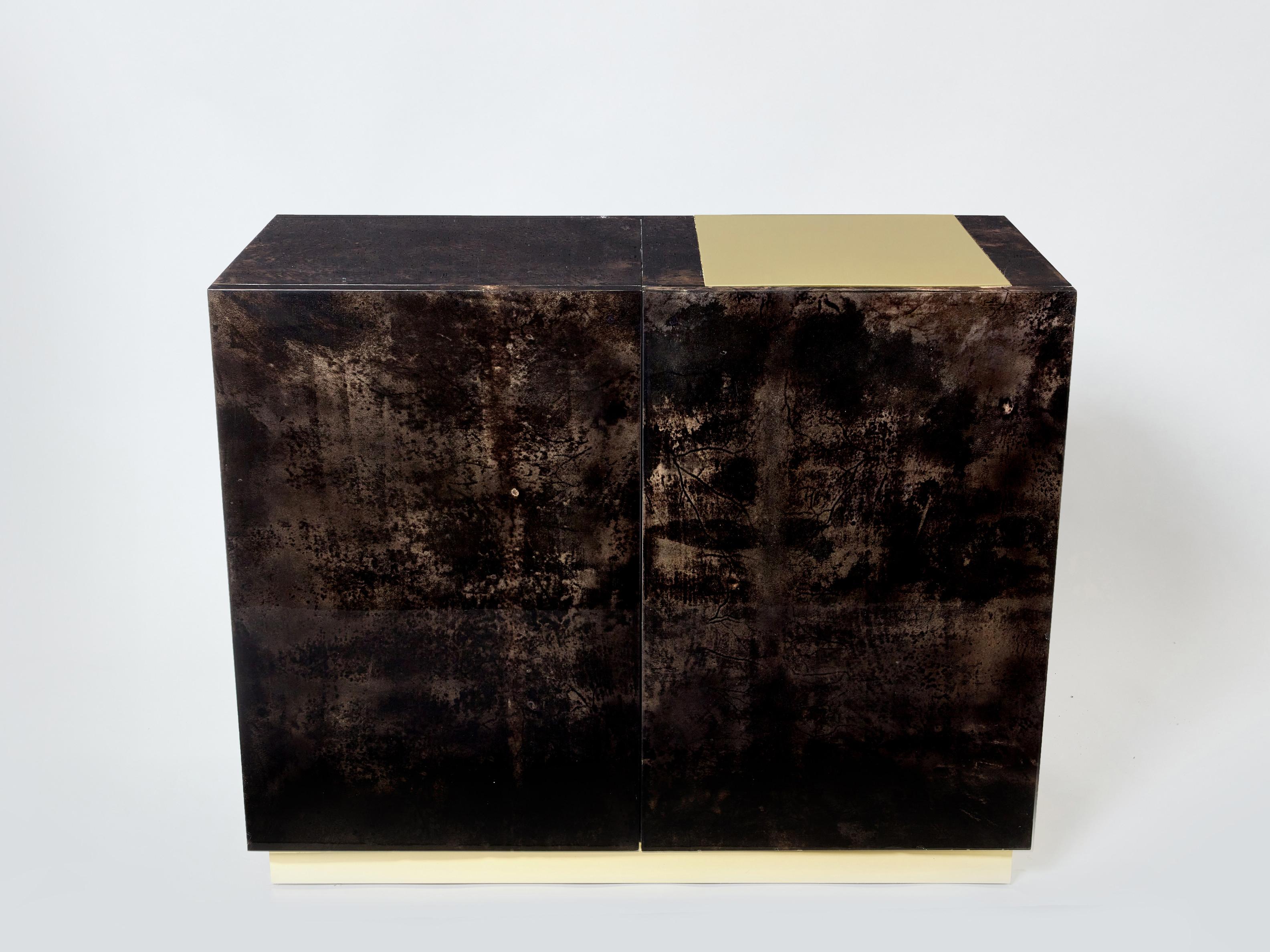 A unique and timeless vintage piece, this Aldo Tura midcentury cabinet bar feels imposing and glamourous. The varnished goatskin parchment, in rich shades of brown and dark brown, makes this cabinet typical of designer Aldo Tura. Its boxy style