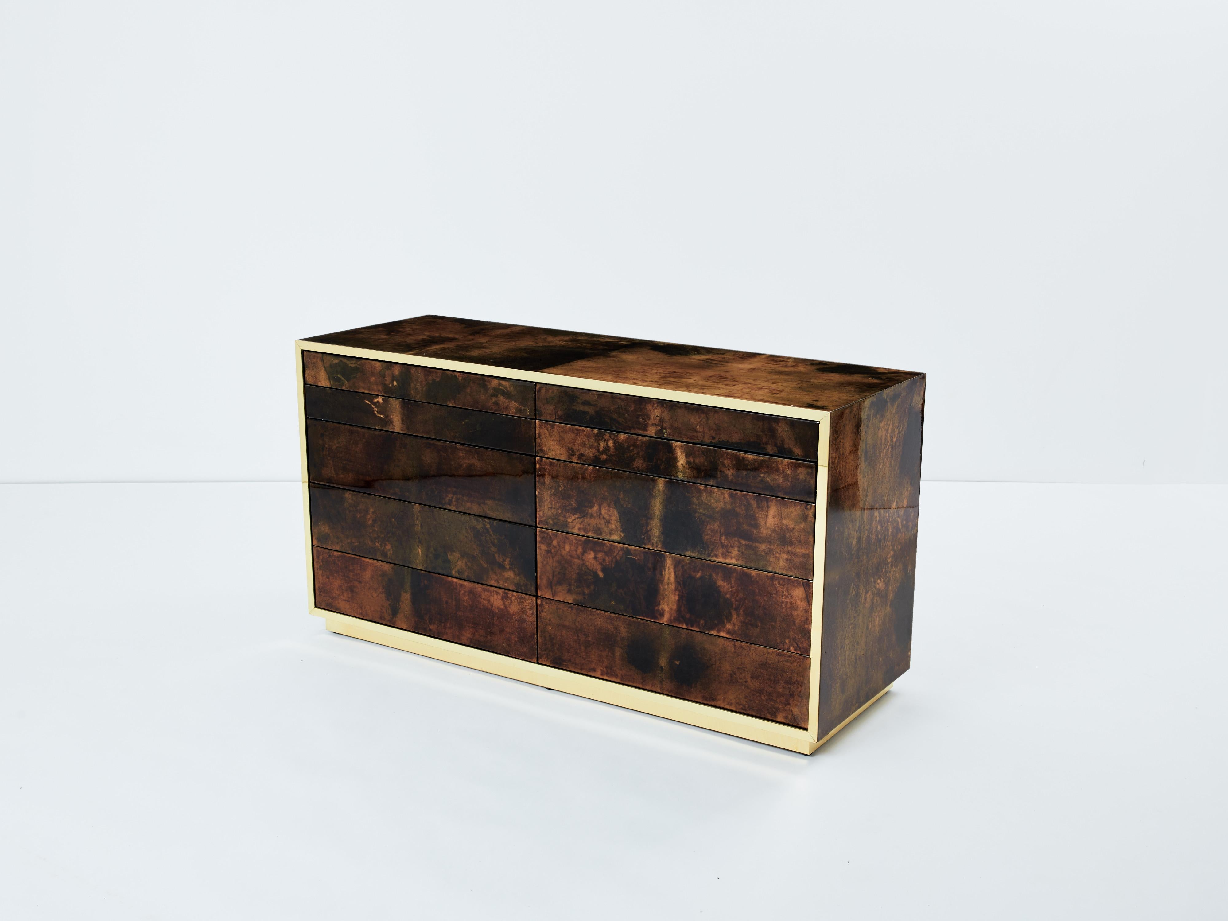A unique and timeless vintage piece, this Aldo Tura mid-century commode feels imposing and glamourous. The varnished goatskin parchment, in rich shades of brown and dark brown, makes this chest of drawers typical of designer Aldo Tura. Its boxy