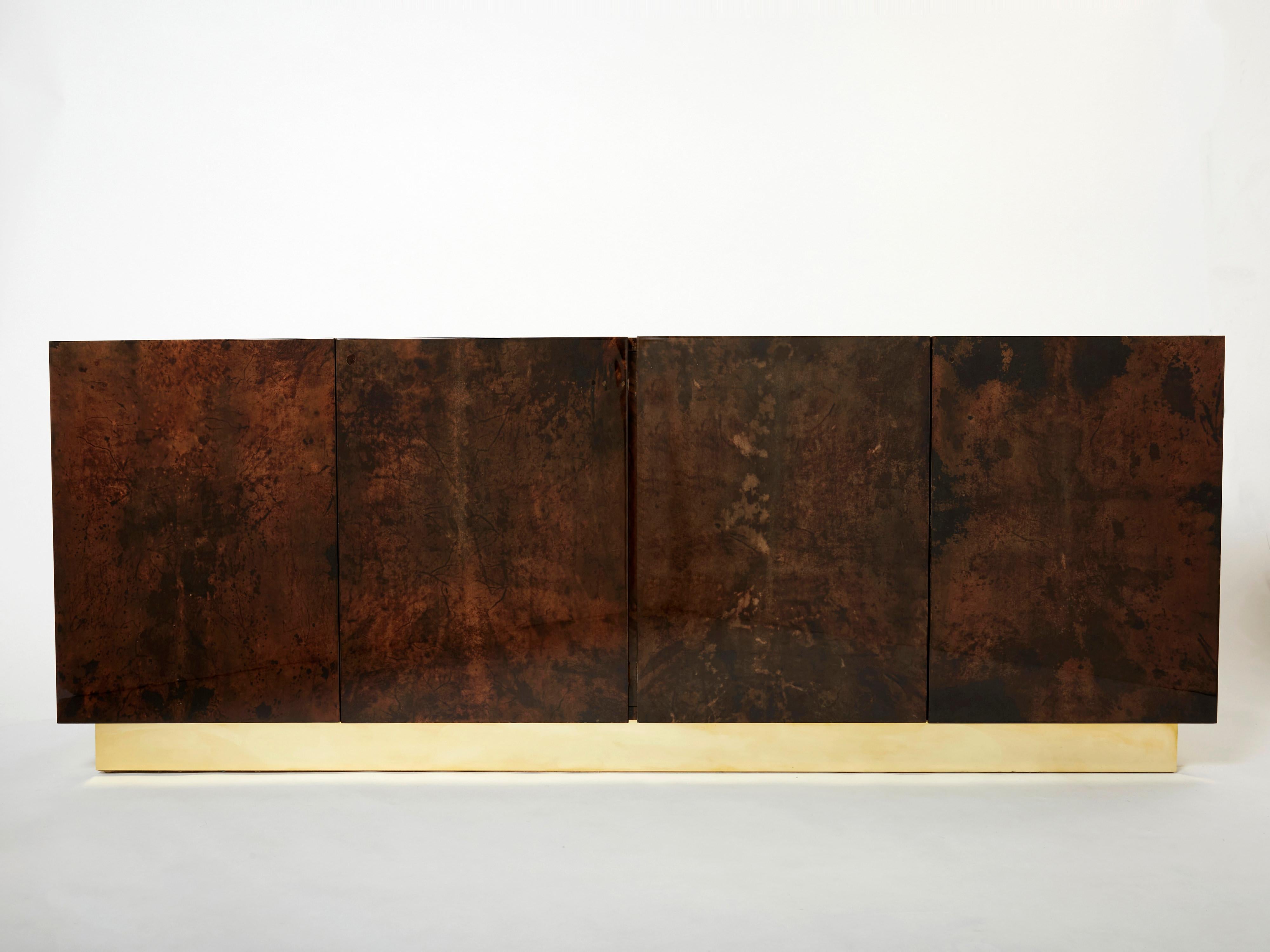 A unique and timeless vintage piece, this Aldo Tura mid-century sideboard feels imposing and glamourous. The varnished goatskin parchment, in rich shades of brown, makes this sideboard typical of designer Aldo Tura. Its boxy, simple style, featuring
