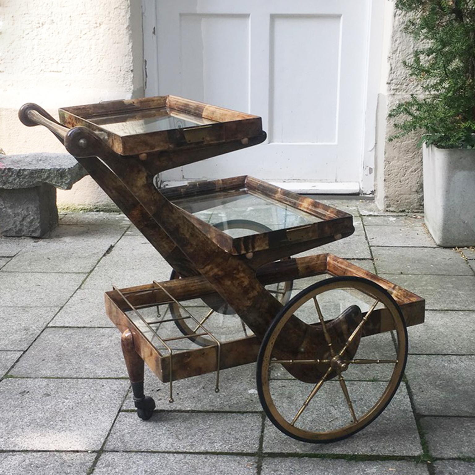 Wonderful bar cart of Aldo Tura in lacquered brown goatskin with two removable trays.
This serving cart was executed, circa 1960 in a brown parchment with brass and rubber wheels and is in very good condition. Along with artists like Piero