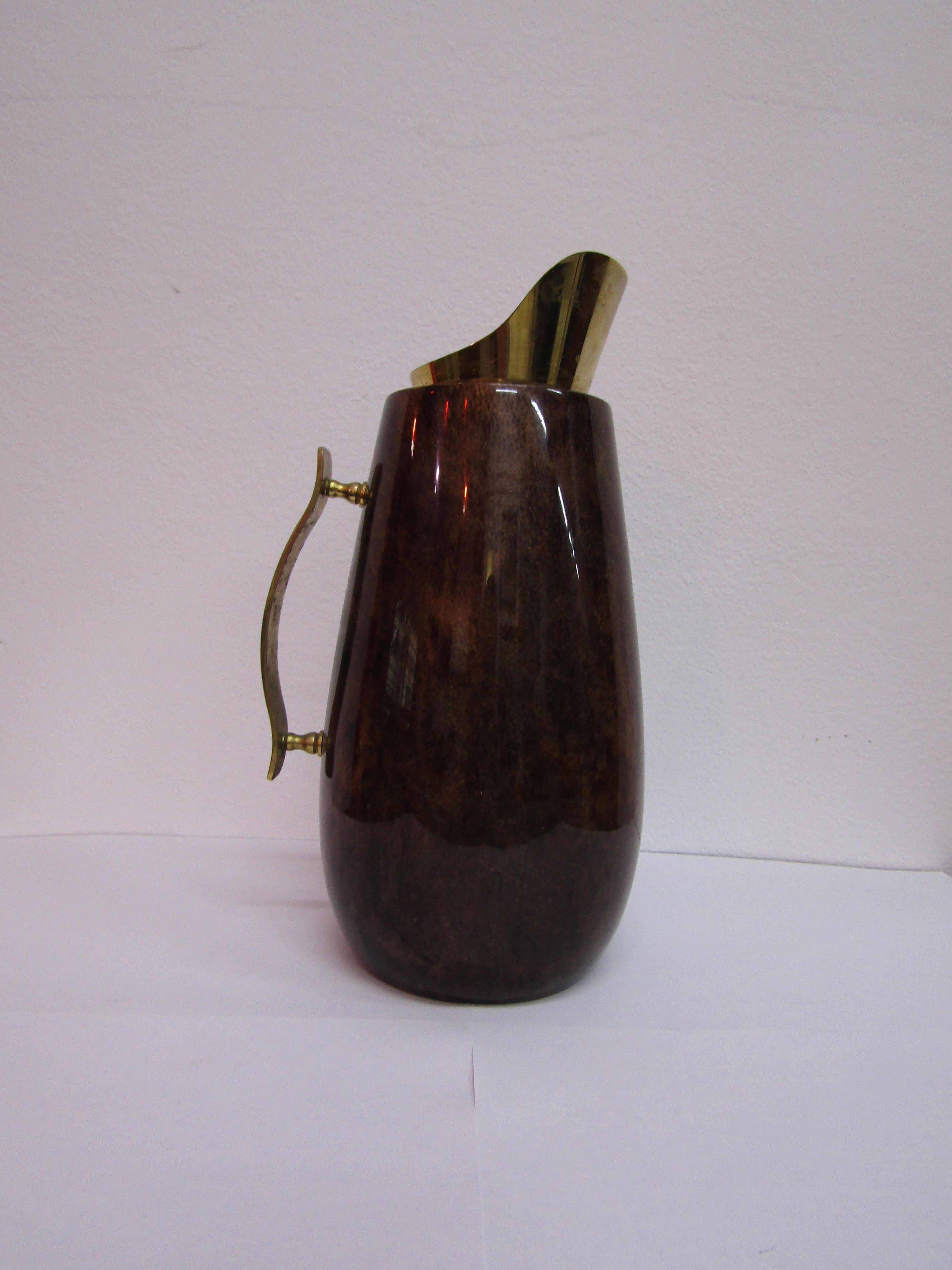 Parchment wooden carafe with brass handle and jug. The carafe still has its original label. Created by Aldo Tura, in Italy in the midcentury

Aldo Tura was not an experimental furniture designer who has been involved in the manual production of
