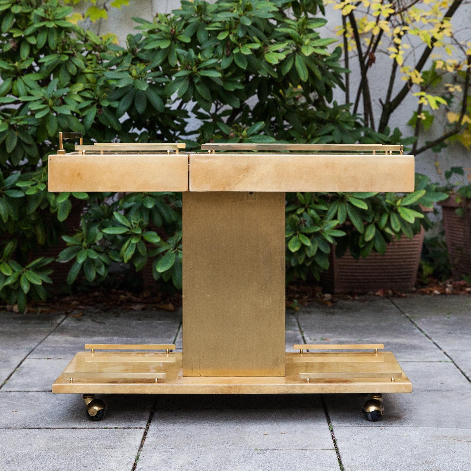 Elegant Aldo Tura bar cart on rolls with a sliding top with a champagne / wine cooler inside. The bar cart has one drawer and brass applications.

This particular bar cart was executed, circa 1970 and is in excellent condition. Along with artists