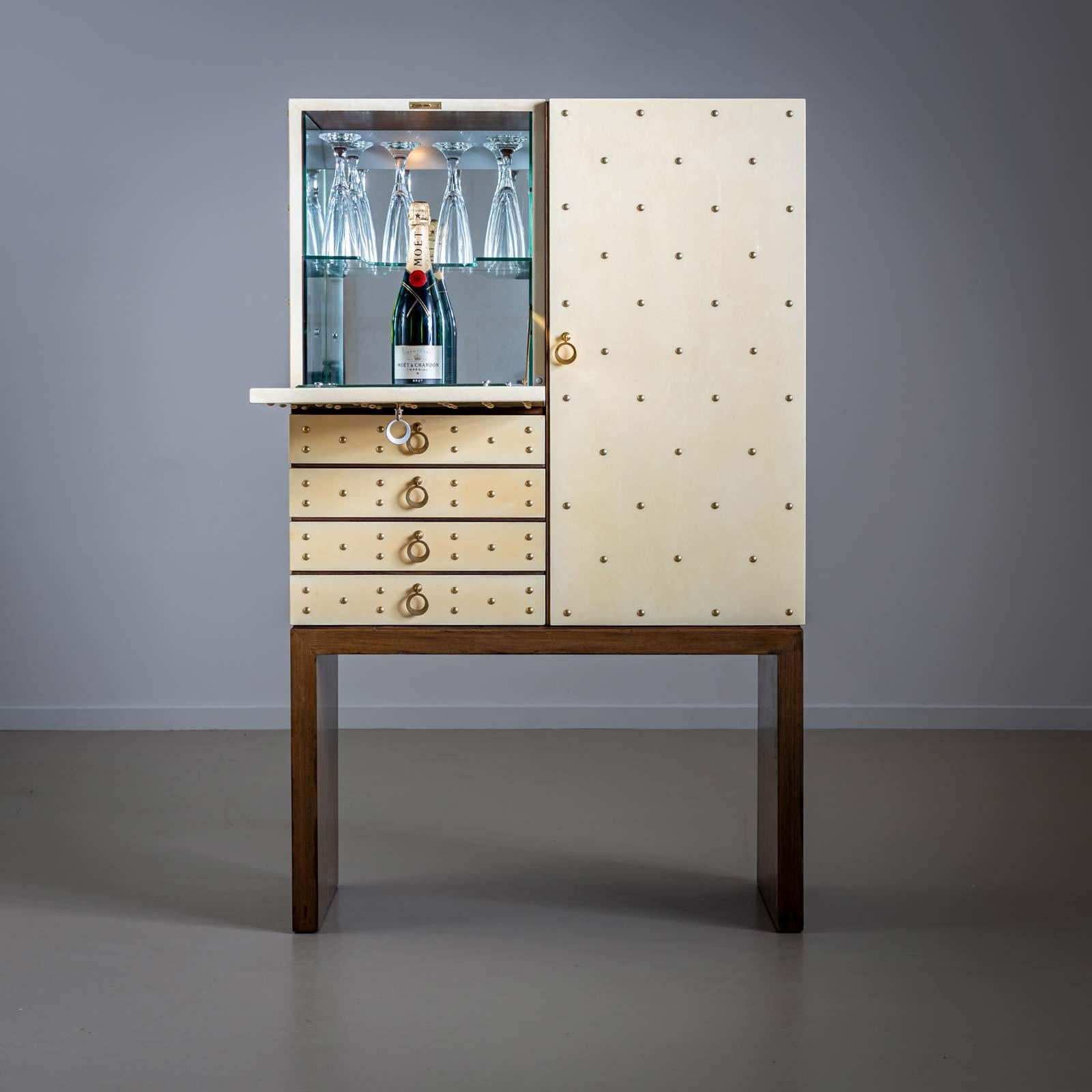 Bar cabinet by Aldo Tura (1909-1963) with goat parchment-covered fronts and straight side panels as a base. The bar cabinet offers plenty of storage space with five drawers, a hinged door on the left and additional storage space with glass holders