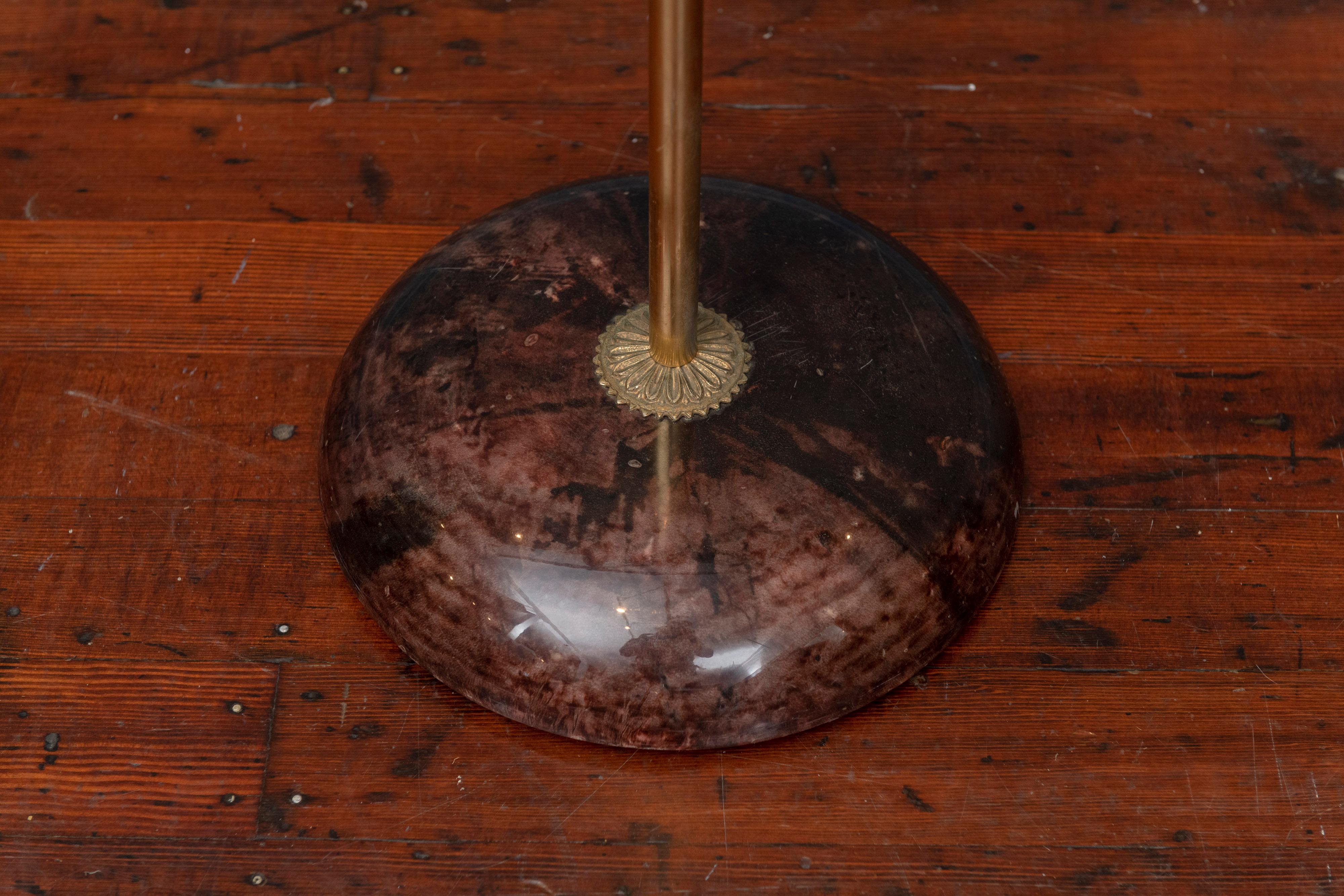 Extravagant, quirky, but ultimately useful bedroom accessory. Marbleized parchment covered coat-hanger and base with gilt center-pole and pant-hanger adorned with acorn finial. 
Aldo Tura sticker on underside of base.