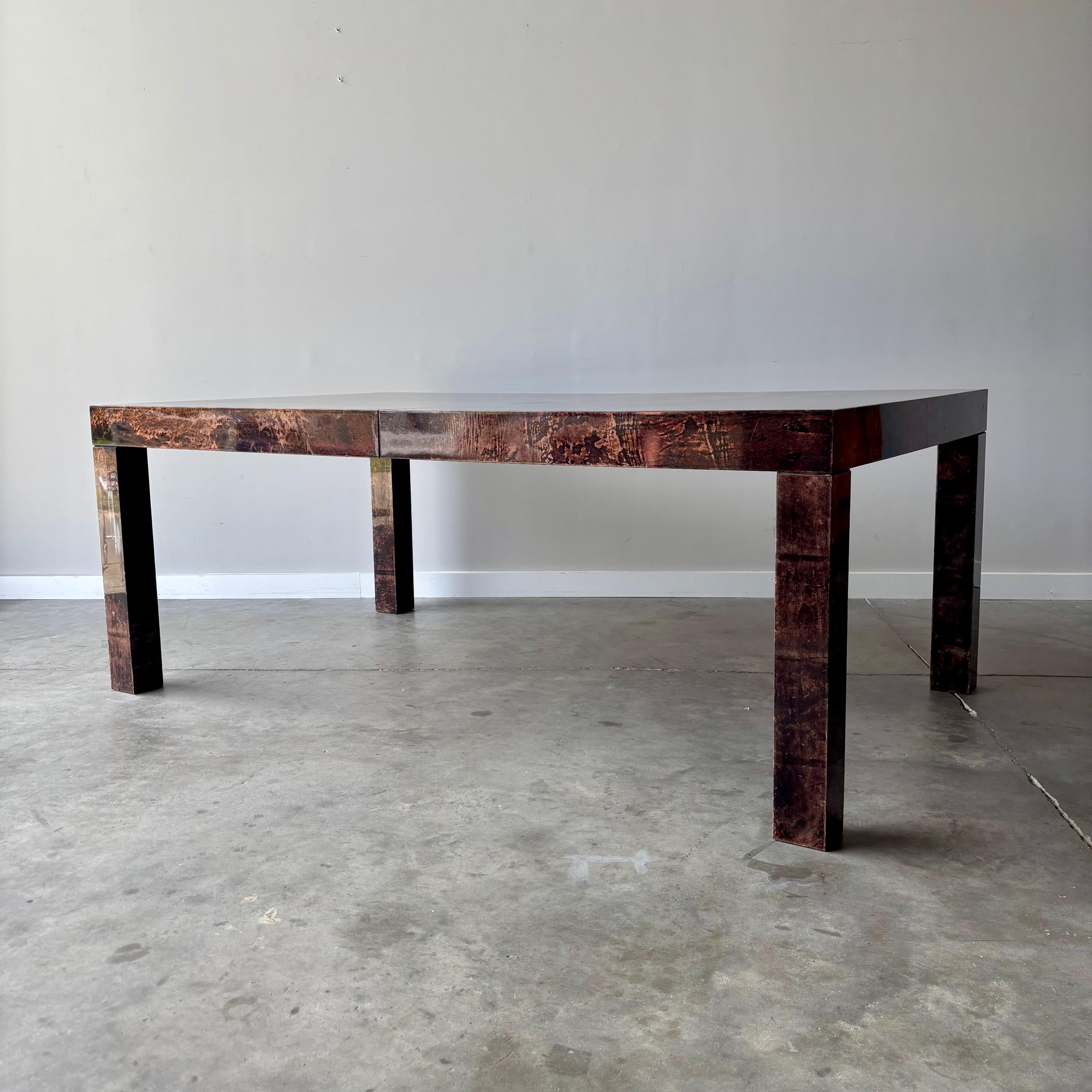 Esta exquisita mesa de piel de cabra ejemplifica la magistral mezcla de artesanía italiana y diseño moderno de mediados de siglo de Aldo Tura. Con unas impresionantes 76 pulgadas de largo por 44 de ancho, esta mesa de comedor llama la atención en