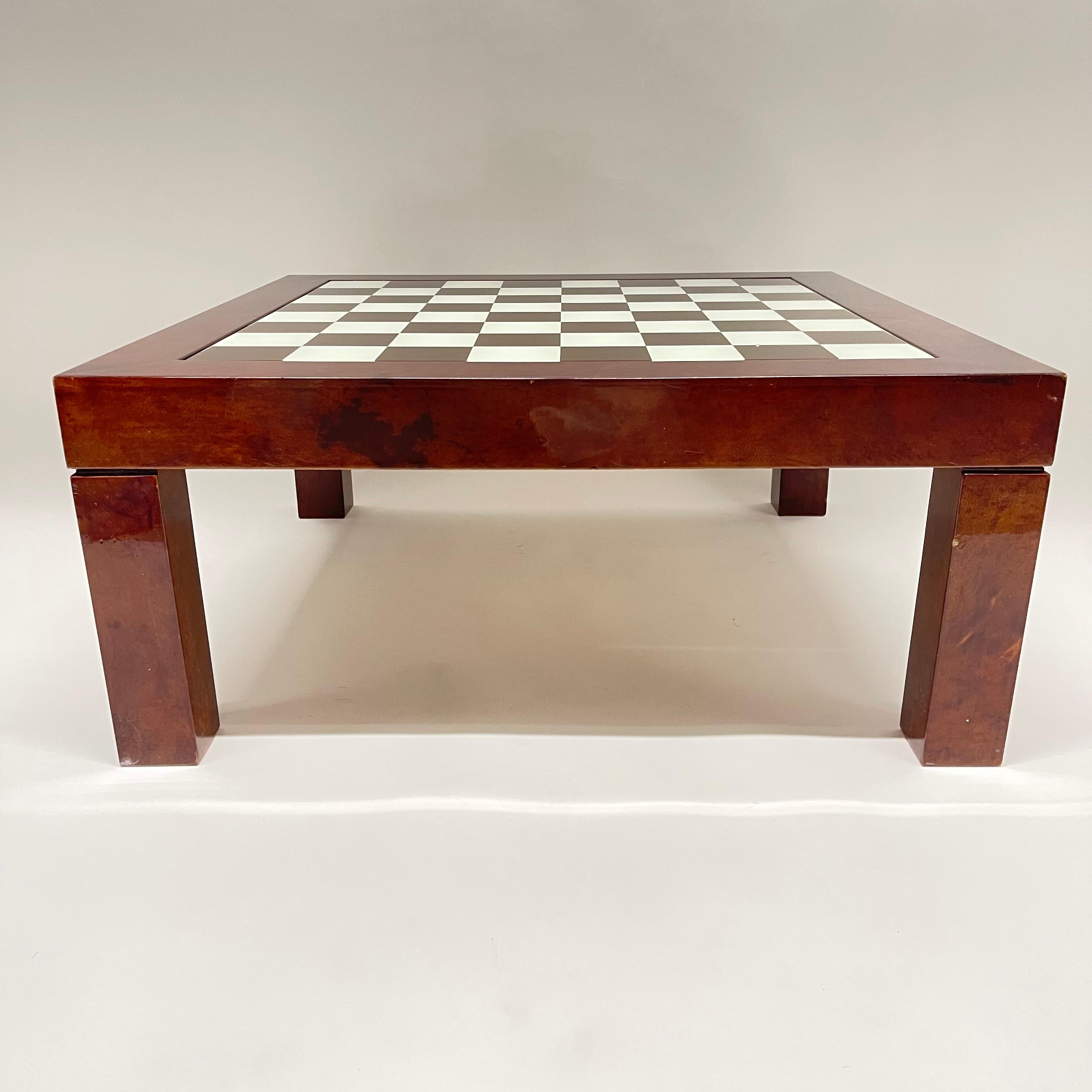 Versatile midcentury parsons coffee or cocktail game table rendered in lacquered goatskin with inset glass checkerboard or chess top, designed by Aldo Tura, Italy, circa 1970s.