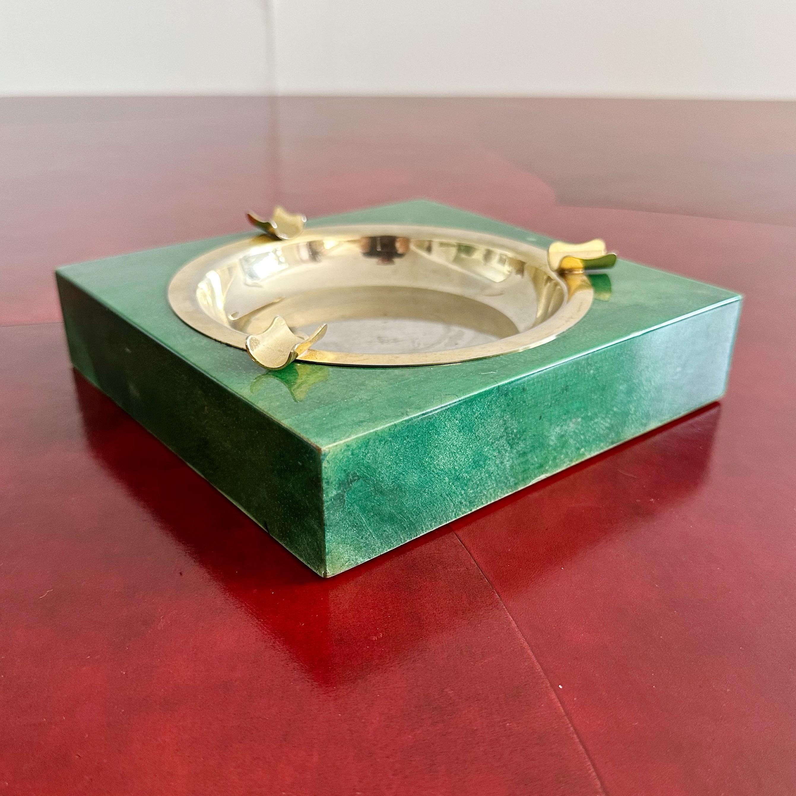 Cenicero de piel de cabra verde Aldo Tura, Italia, años 60. Piel de cabra verde sobre madera con bandeja de latón extraíble. Etiqueta de papel en la parte inferior. En buen estado vintage, con pequeños desgastes superficiales y propios de la edad.