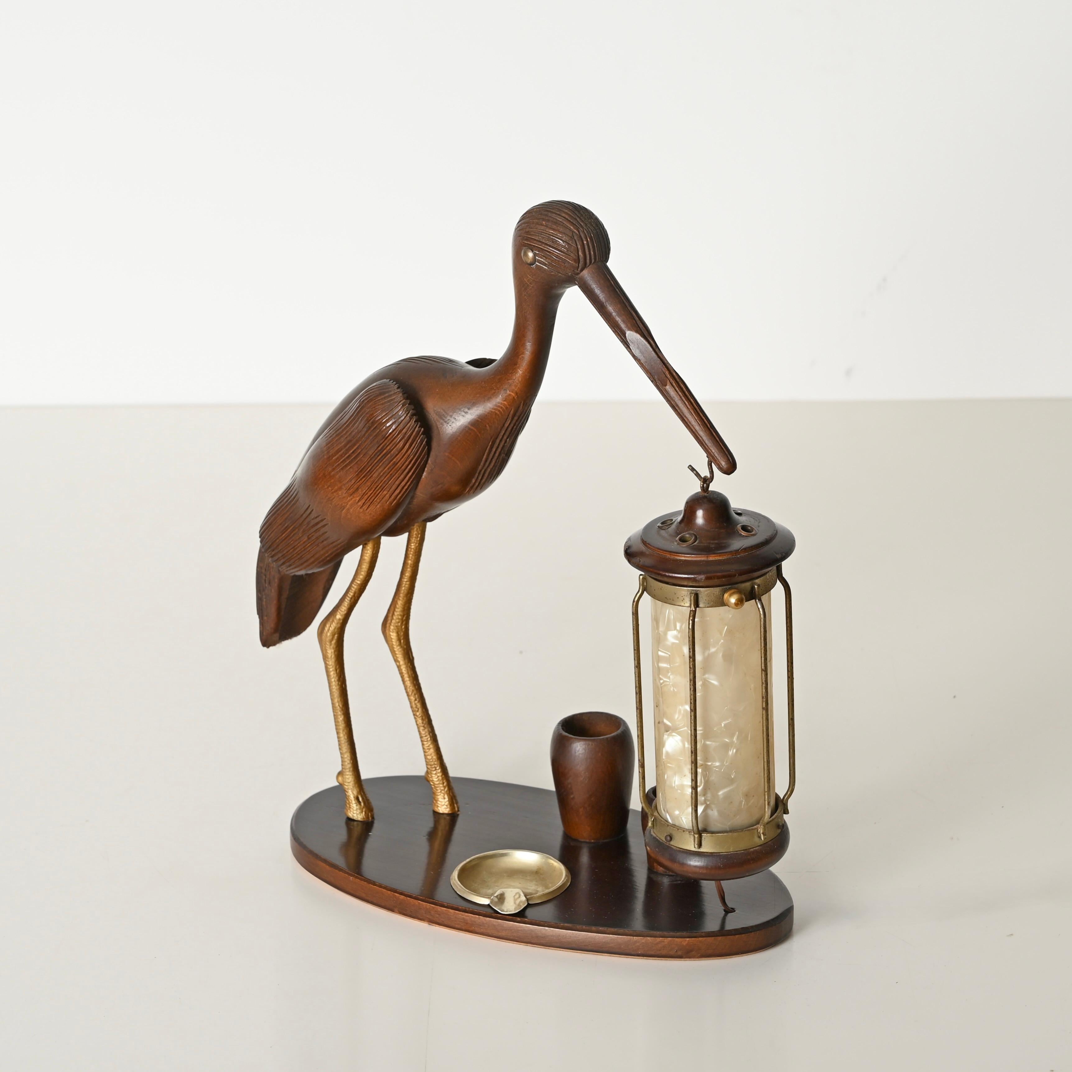 Unglaublich seltene und elegante Tischlampe in Form eines Reihers aus handgeschnitztem Nussbaumholz, vergoldeter Bronze und Perlmutt. Diese wunderschöne Lampe wurde von Aldo Tura entworfen und von Macabo in den 1950er Jahren in Italien hergestellt.