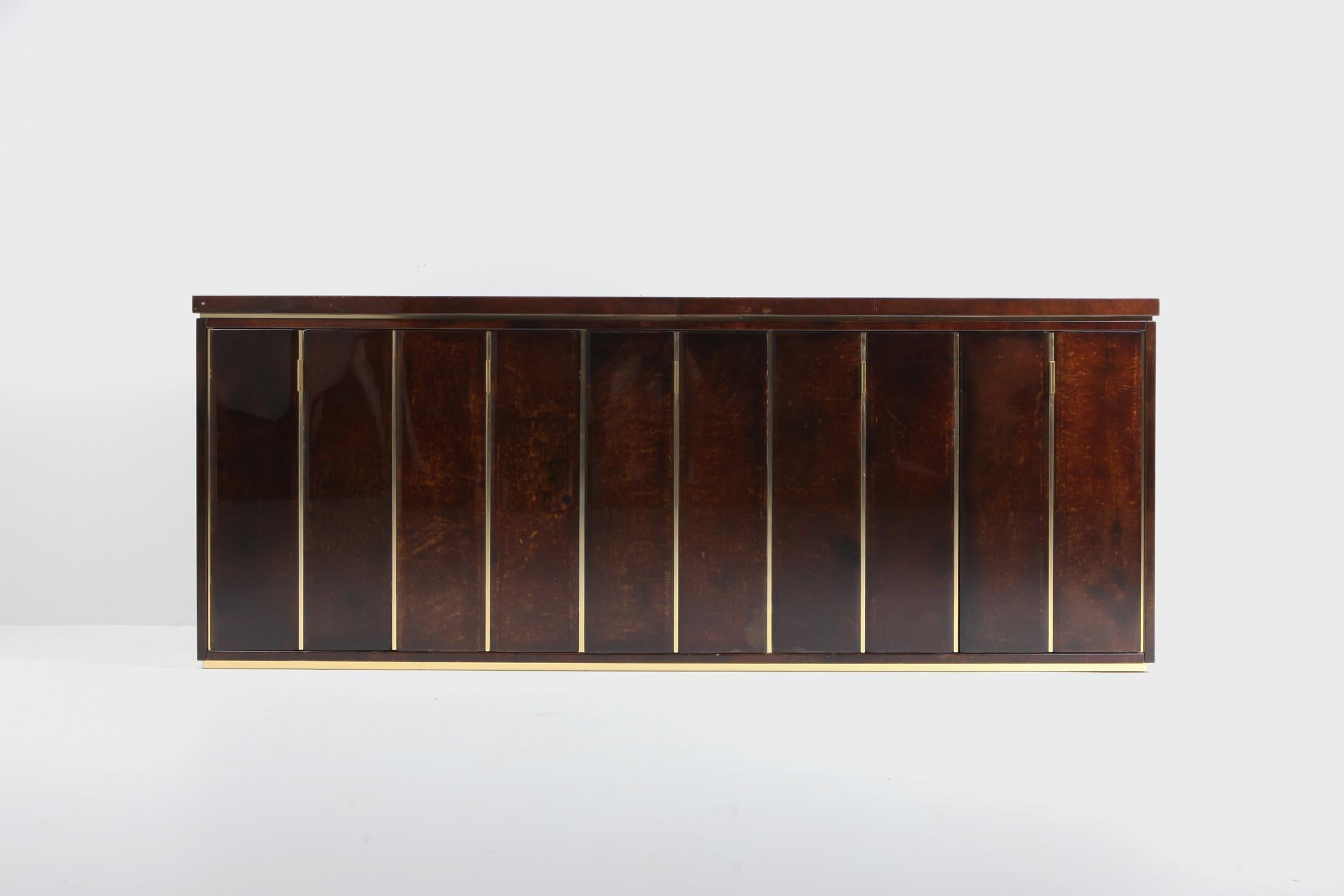 Postmodern metropolitan chic sideboard in lacquered parchment and brass by Aldo Tura, Italy, 1960s.

In our extra images you see the piece presented with two cognac leather camaleonda lounge chairs buy Mario Bellini and an Aldo Tura sliding top